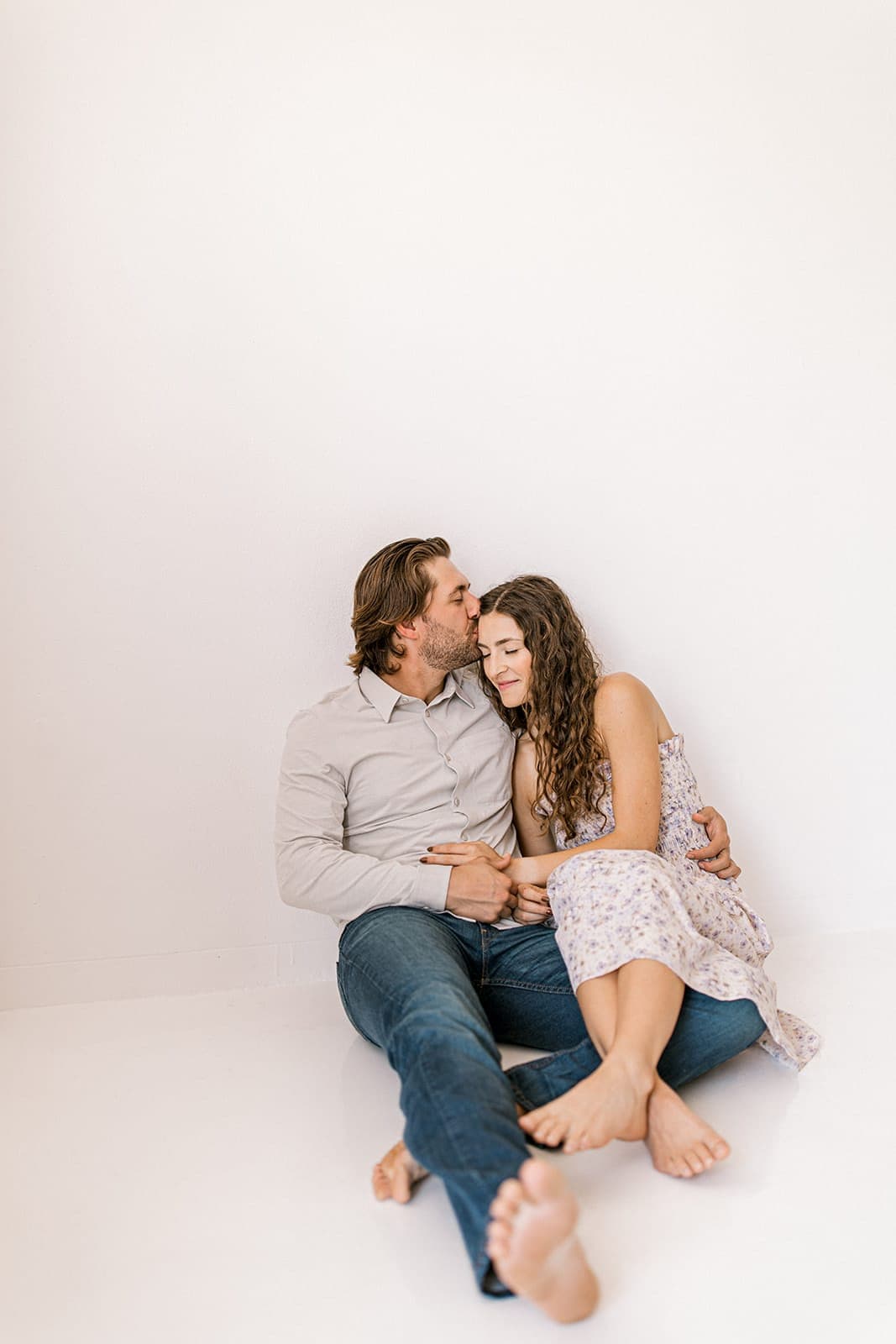 A couple shares a tender embrace while standing close together during their natural light engagement shoot at Revelator Studio in Shreveport.