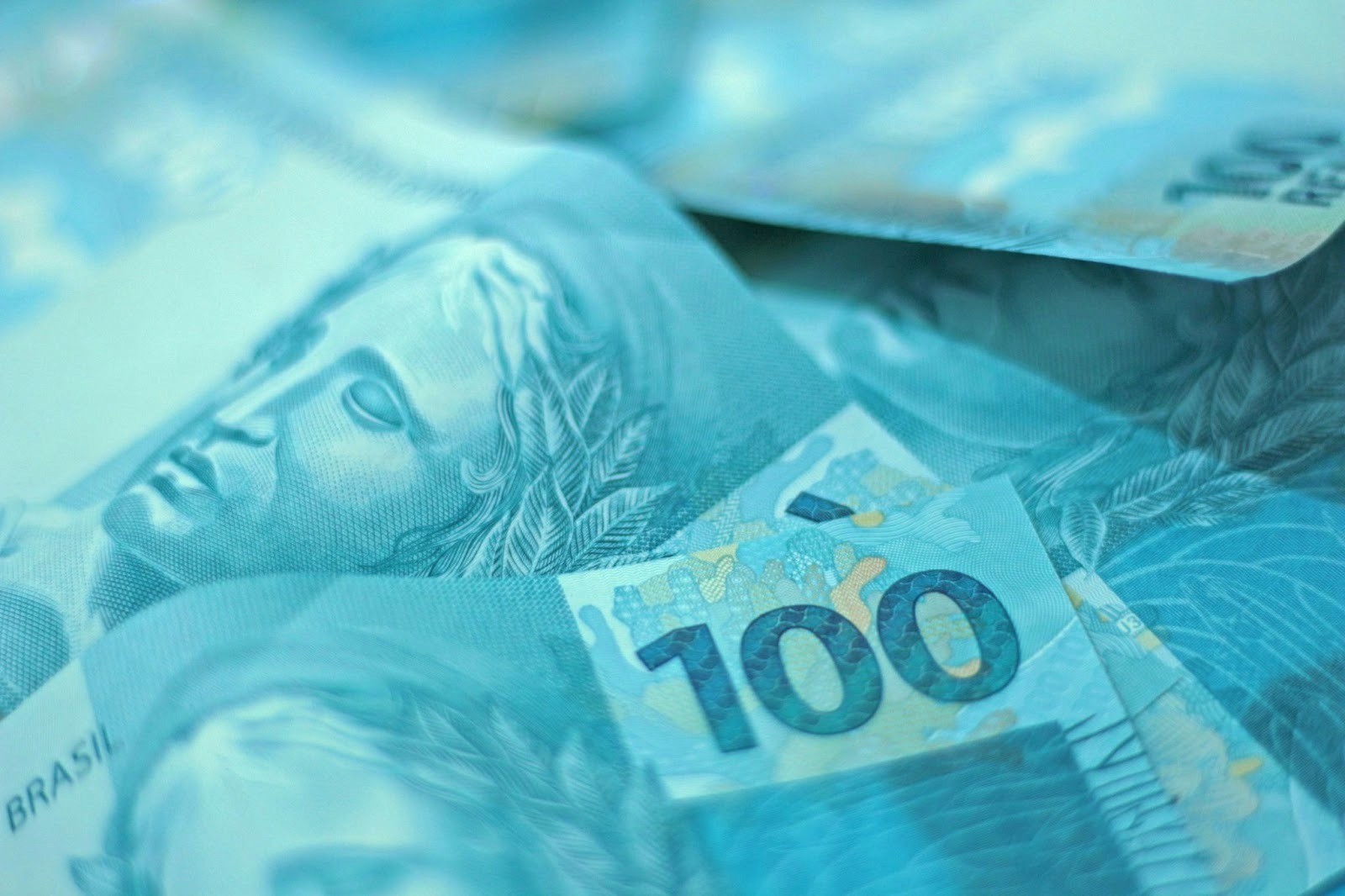 A pile of Brazilian currency – the Brazilian real – is shown in a close-up image.