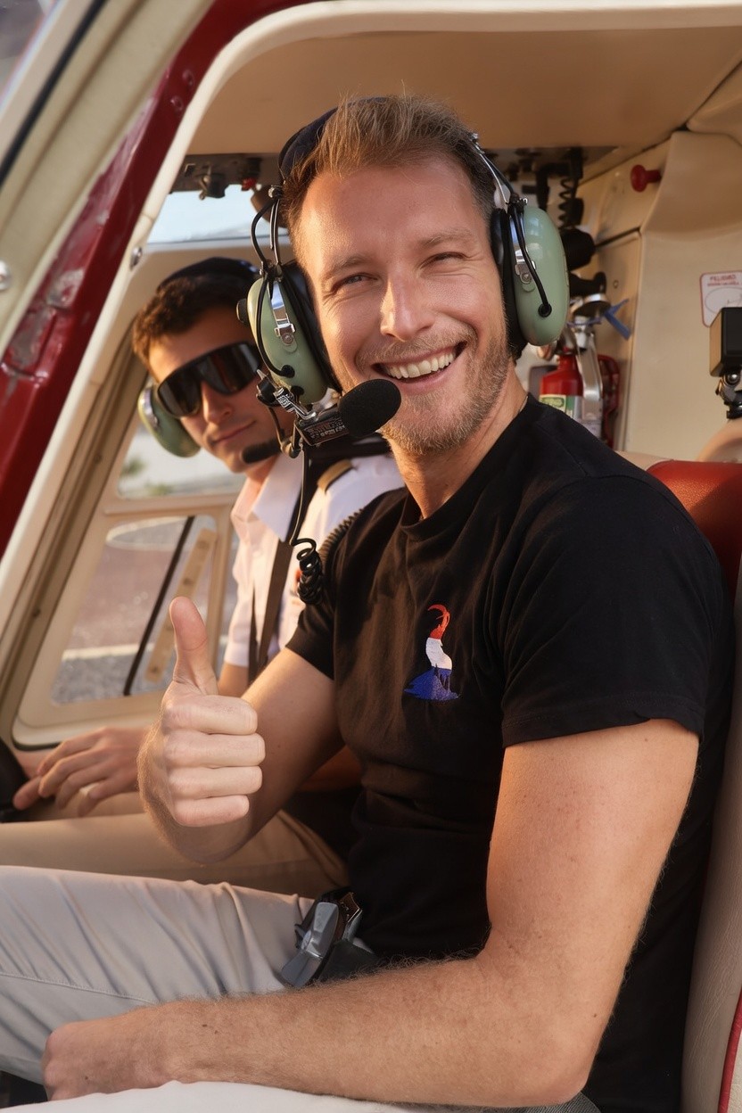 Portrait of a laughing person with curly hair wearing a white shirt