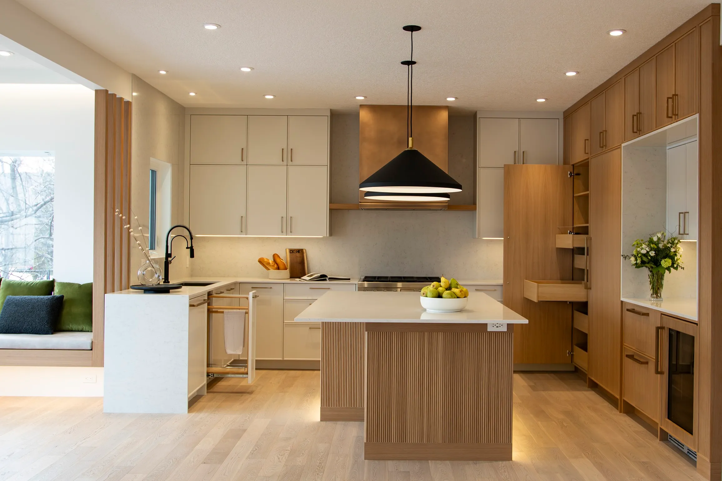 Image of warm modern kitchen with triangle shaped pendant lights over a fluted wood island.