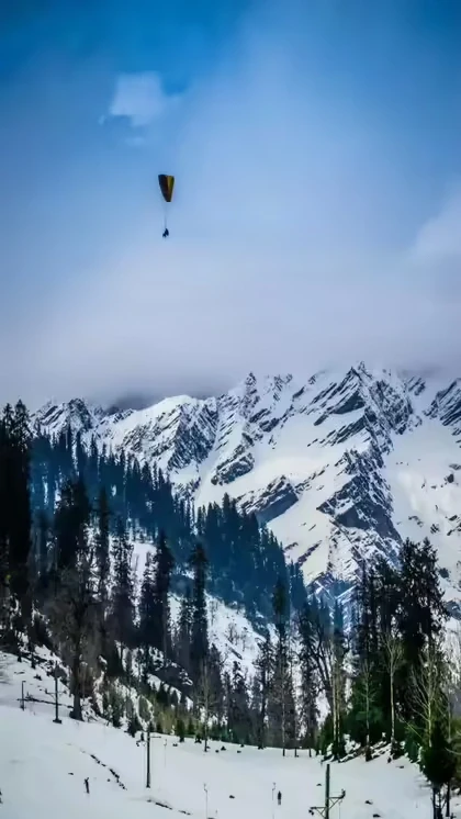 Paragliding above snowy mountains