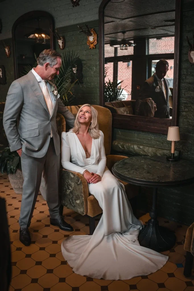 Newlyweds posing together inside a dimly lit lounge