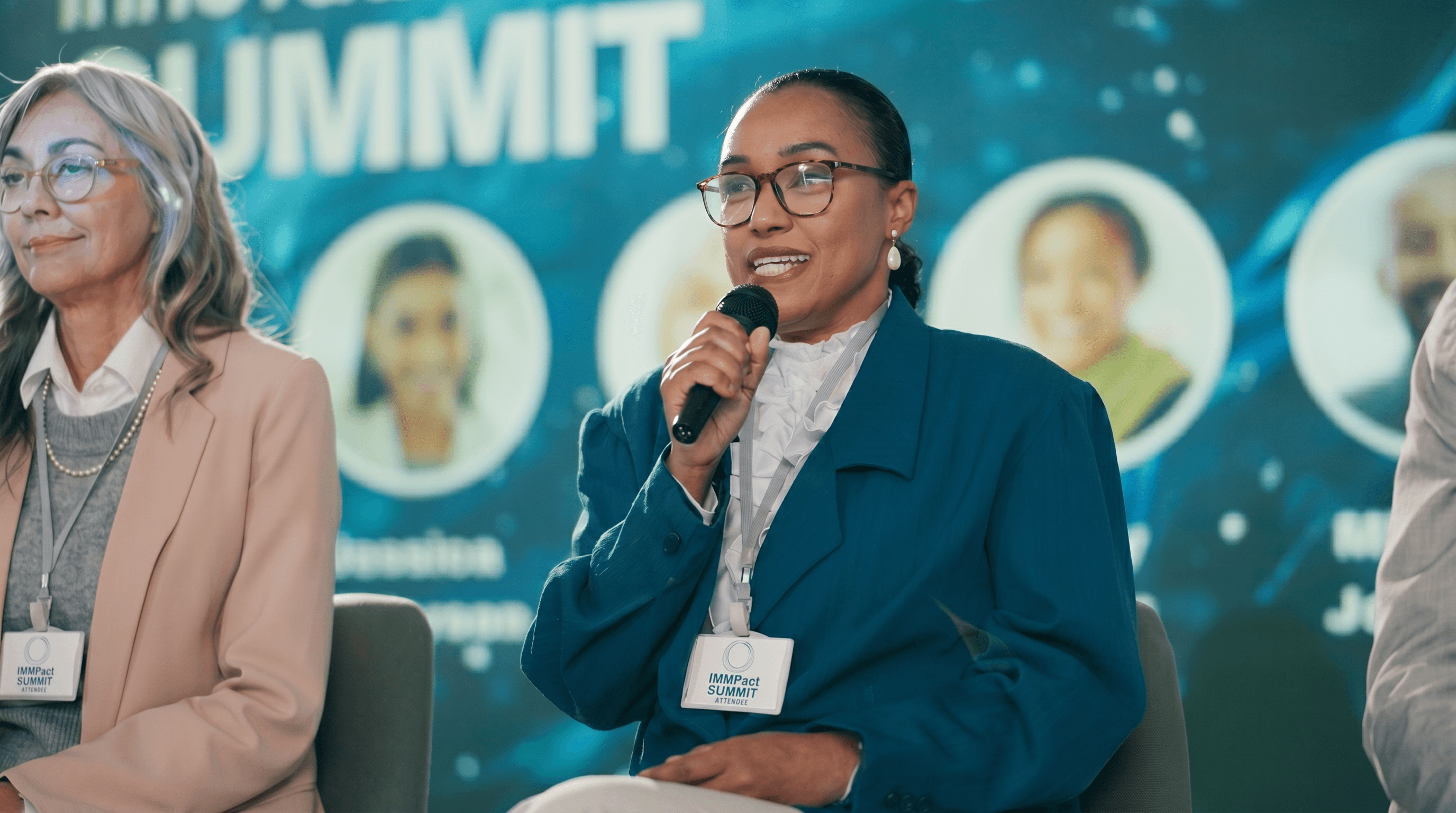Group of people standing around a white desk during a casual meeting with laptops and coffee cups.
