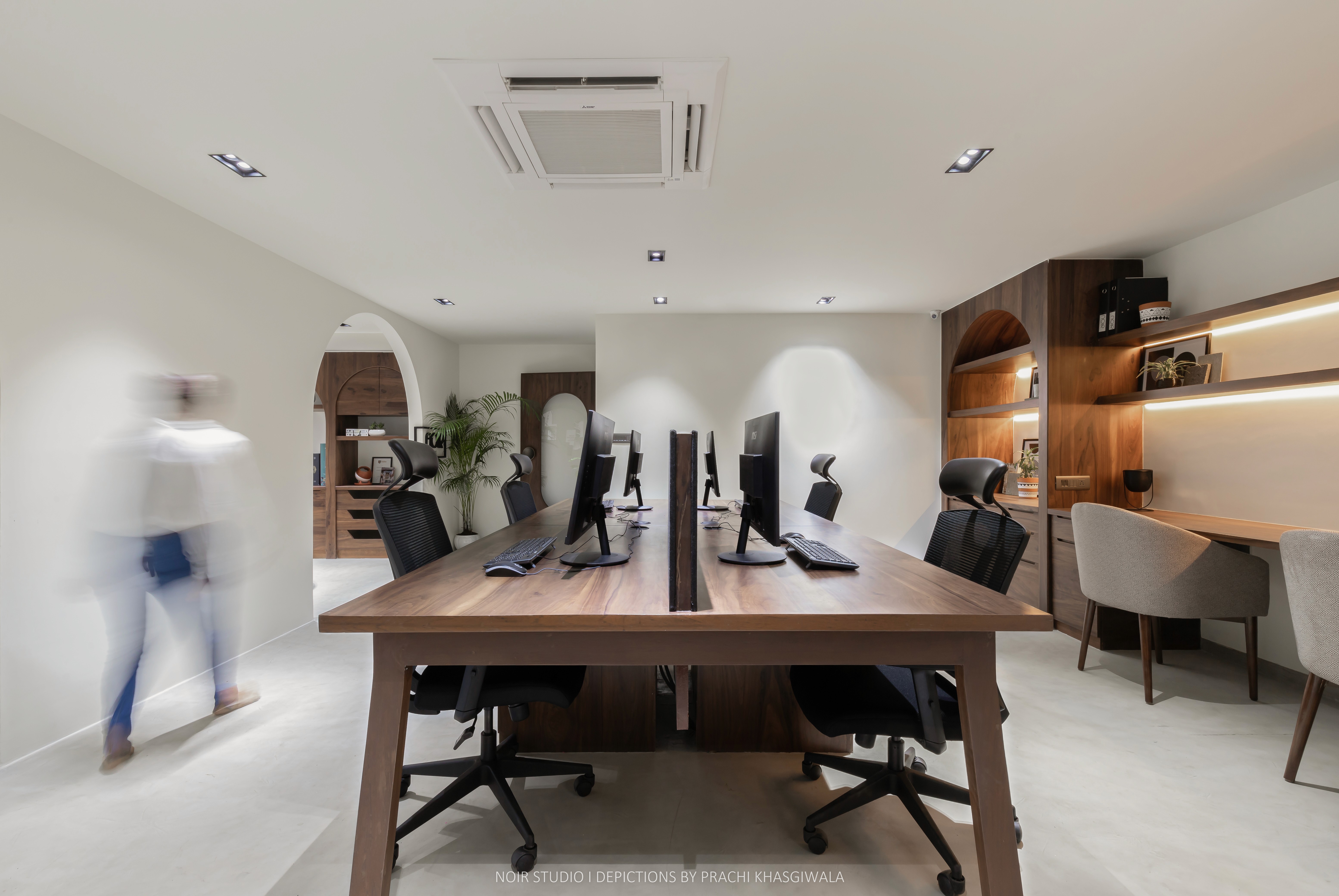 Black and white image of people working at a table with laptops, showing hands gesturing during discussion of digital content displayed on screens, with fabrica® logo in the corner.