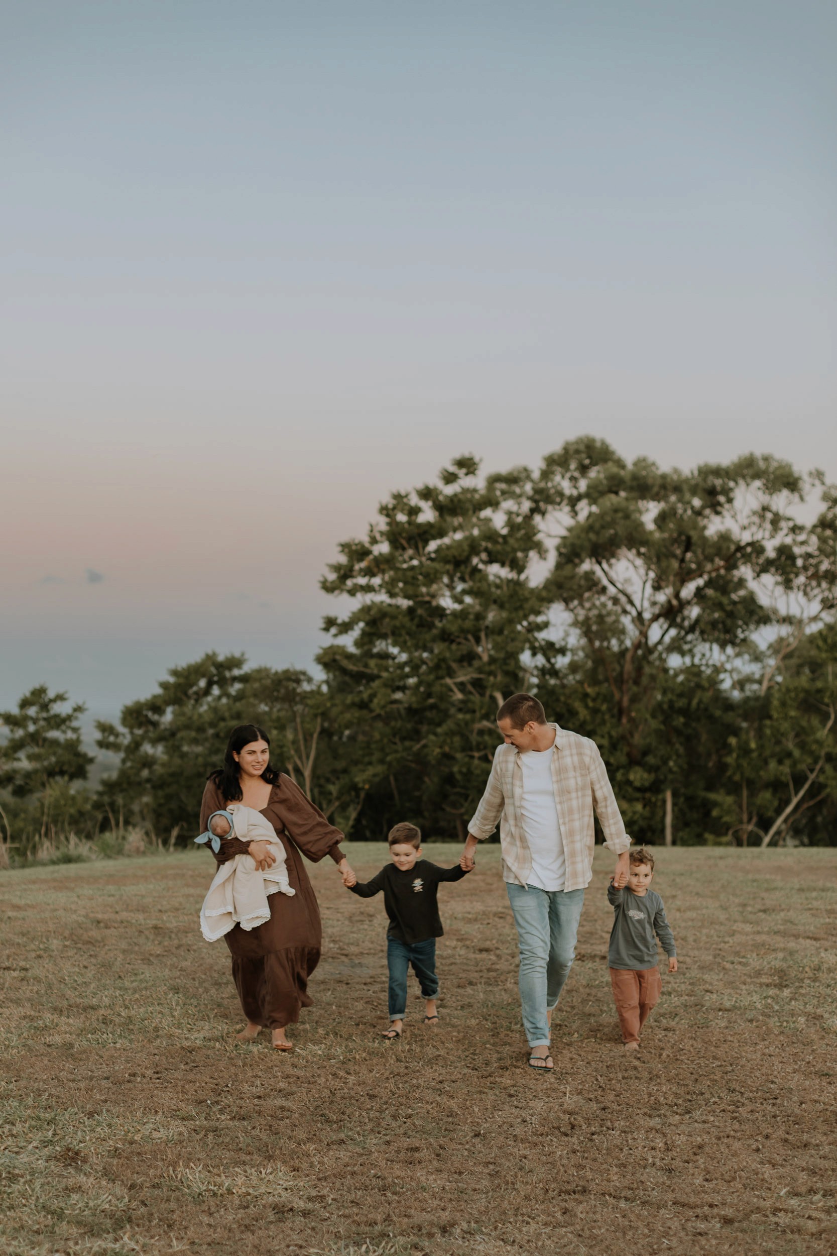 Family holding hands walking at sunset photoshoot Mackay