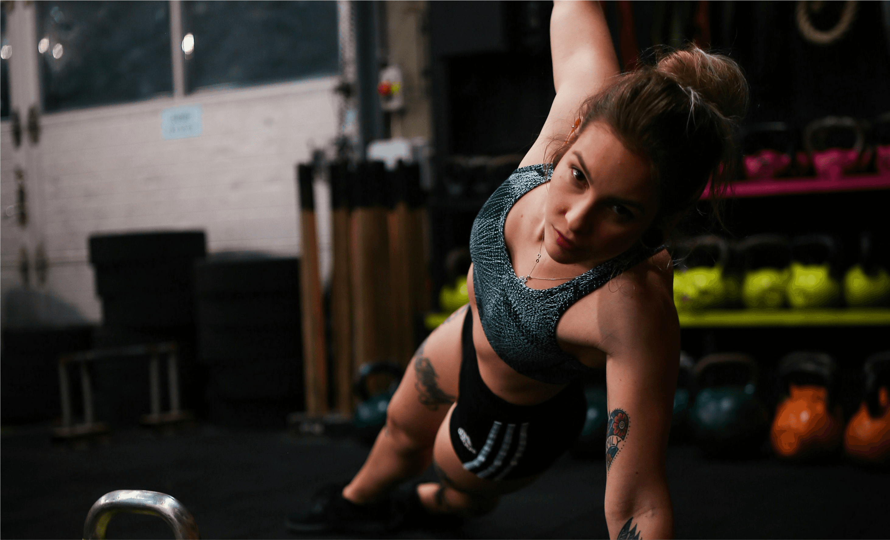 Woman doing push-ups on the gym floor, focused and determined during a personal training session.