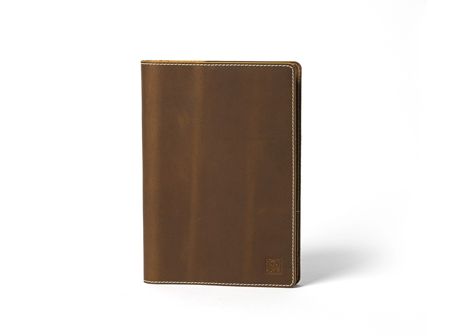 Front view of standing brown leather notebook with white stitching details.
