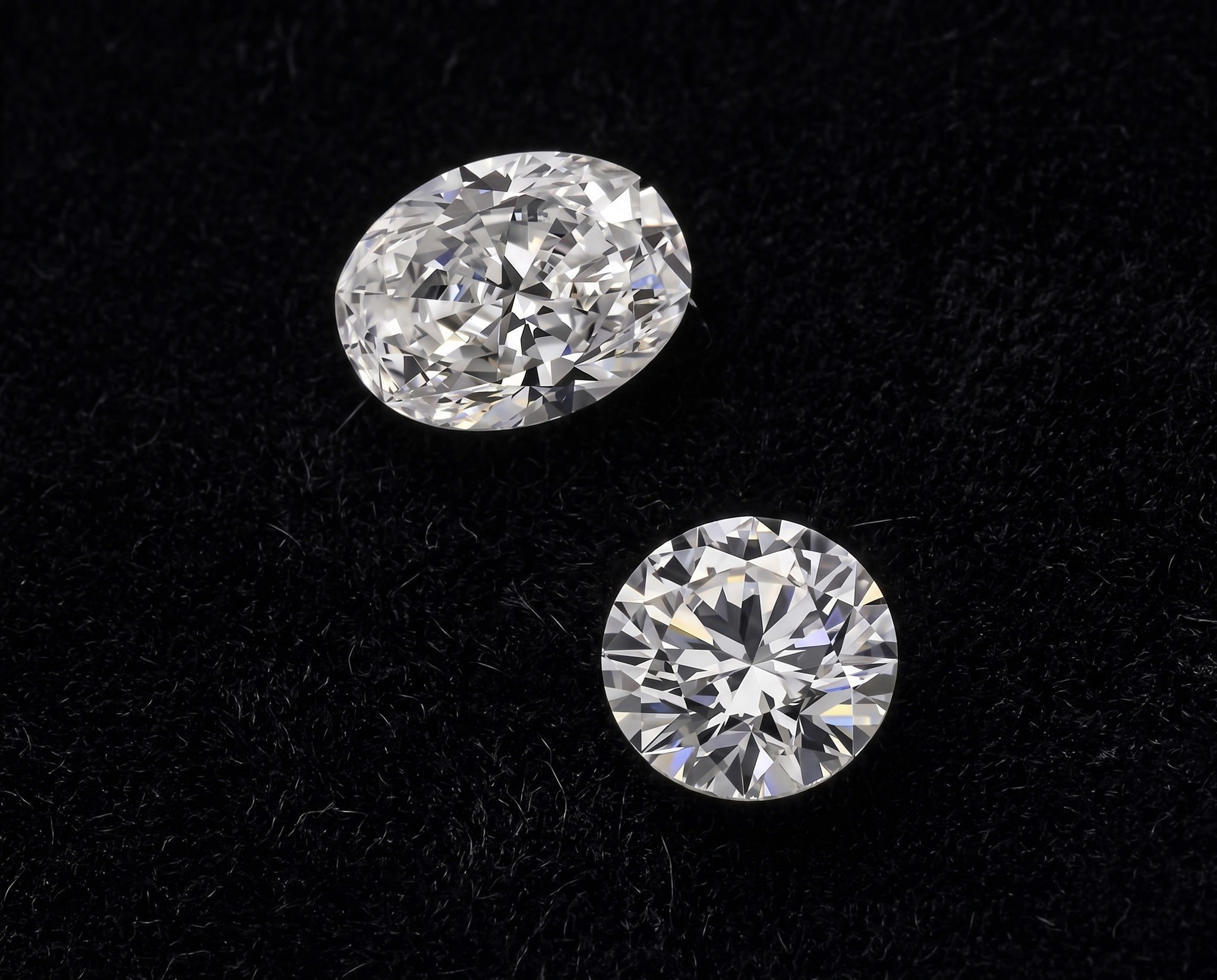 An oval and a round diamond ring to compare on the background.