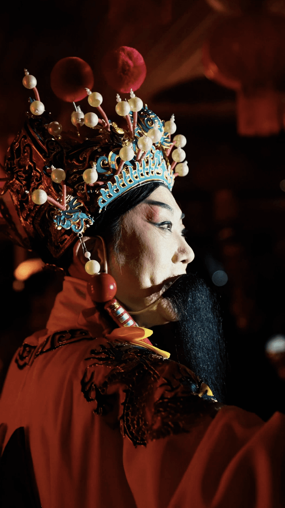 Dancer in black outfit with arms raised, arching backwards