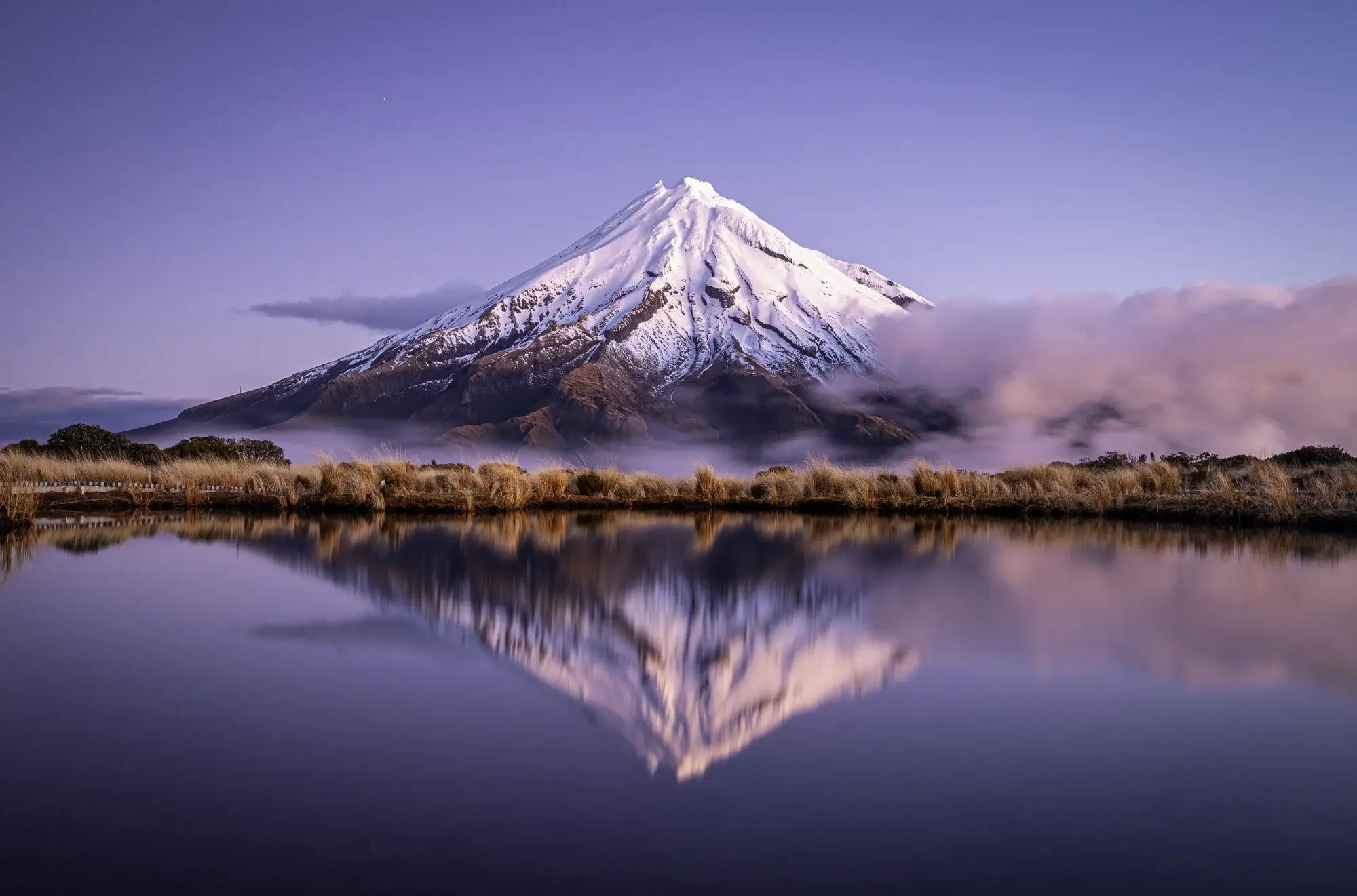 A beautiful landscape shot of Mt Taranaki with the mountain reflecting on the pond in front of it