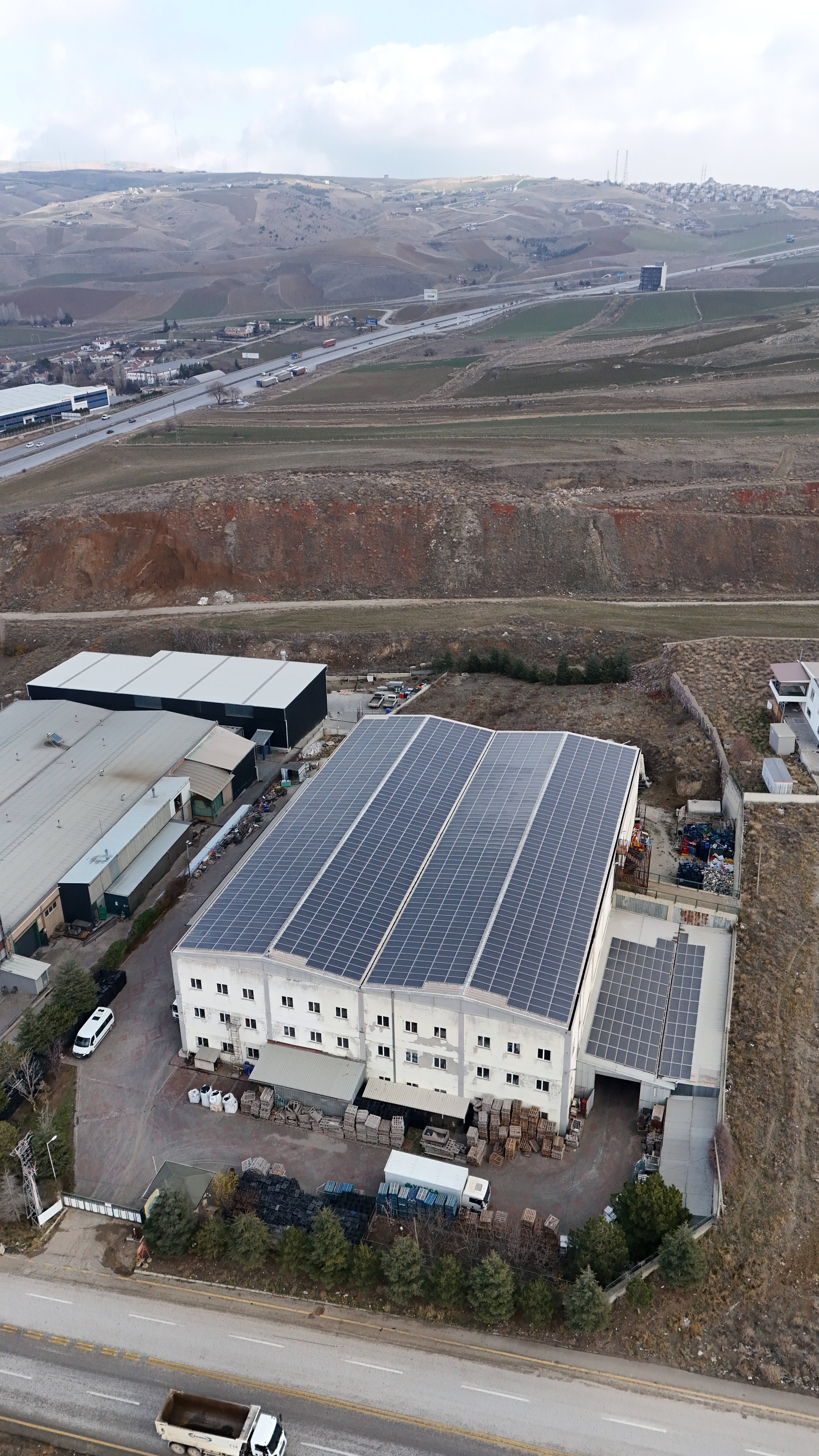 Close-up view of a large-scale logistics depot with organized storage areas and solar-paneled roof.