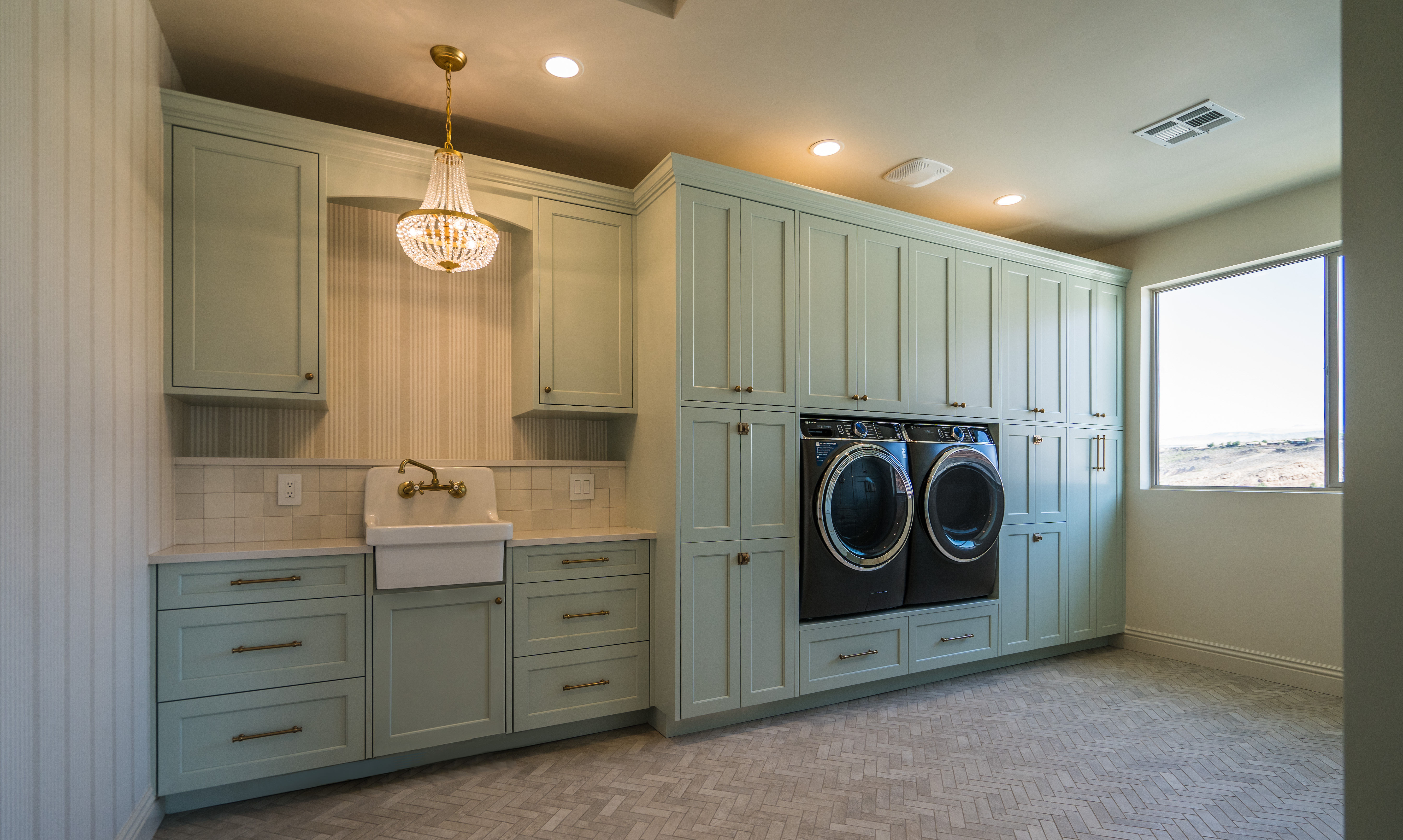 Laundry room with a chandlier over the sink in a Washington, Utah custom home.