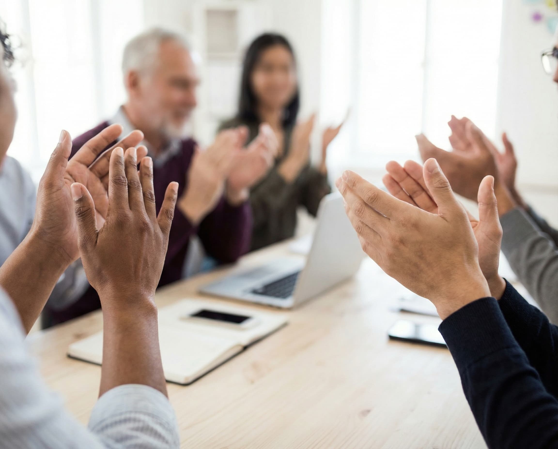 Hands clapping during a team meeting