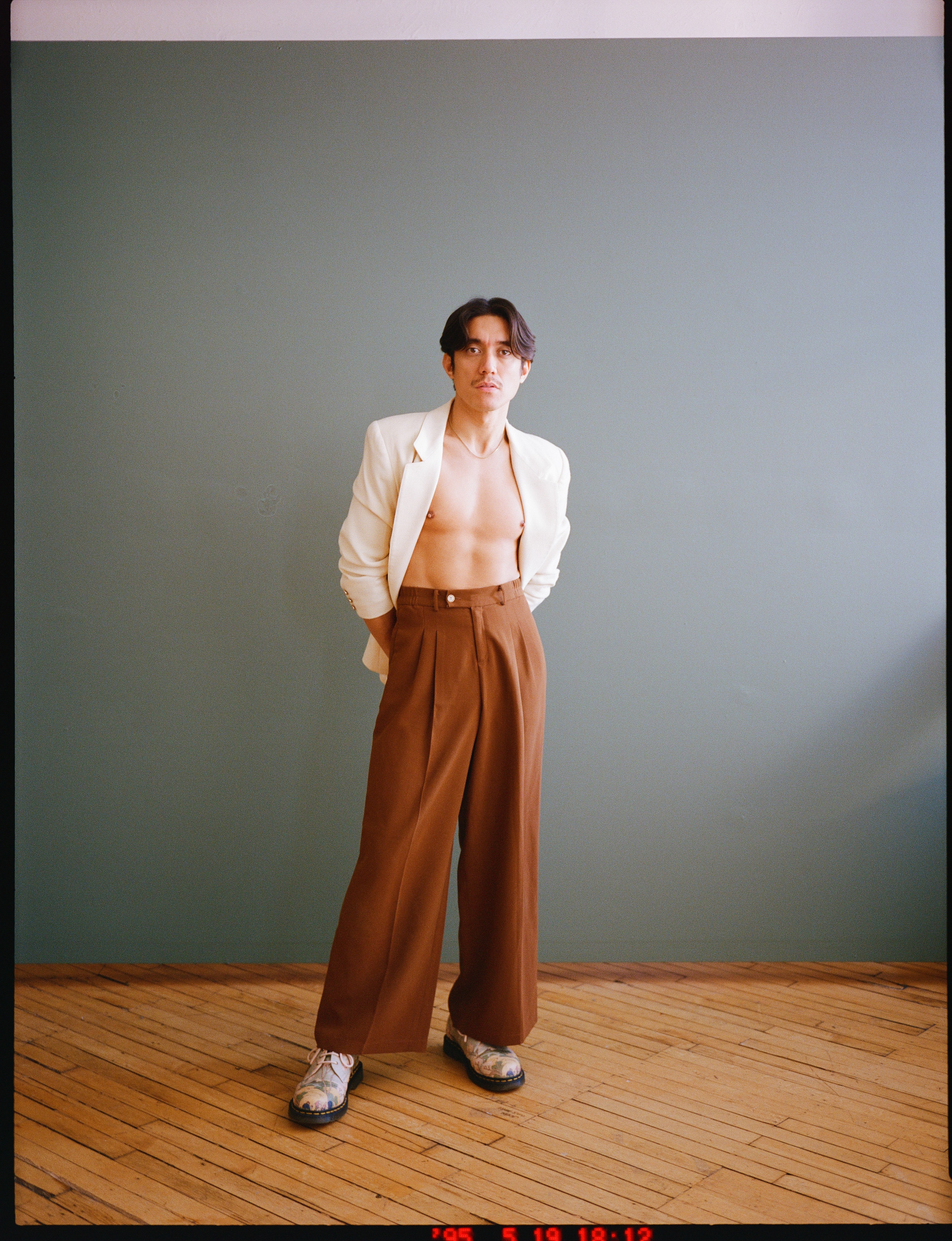 Young woman in casual clothing posing against a white background.