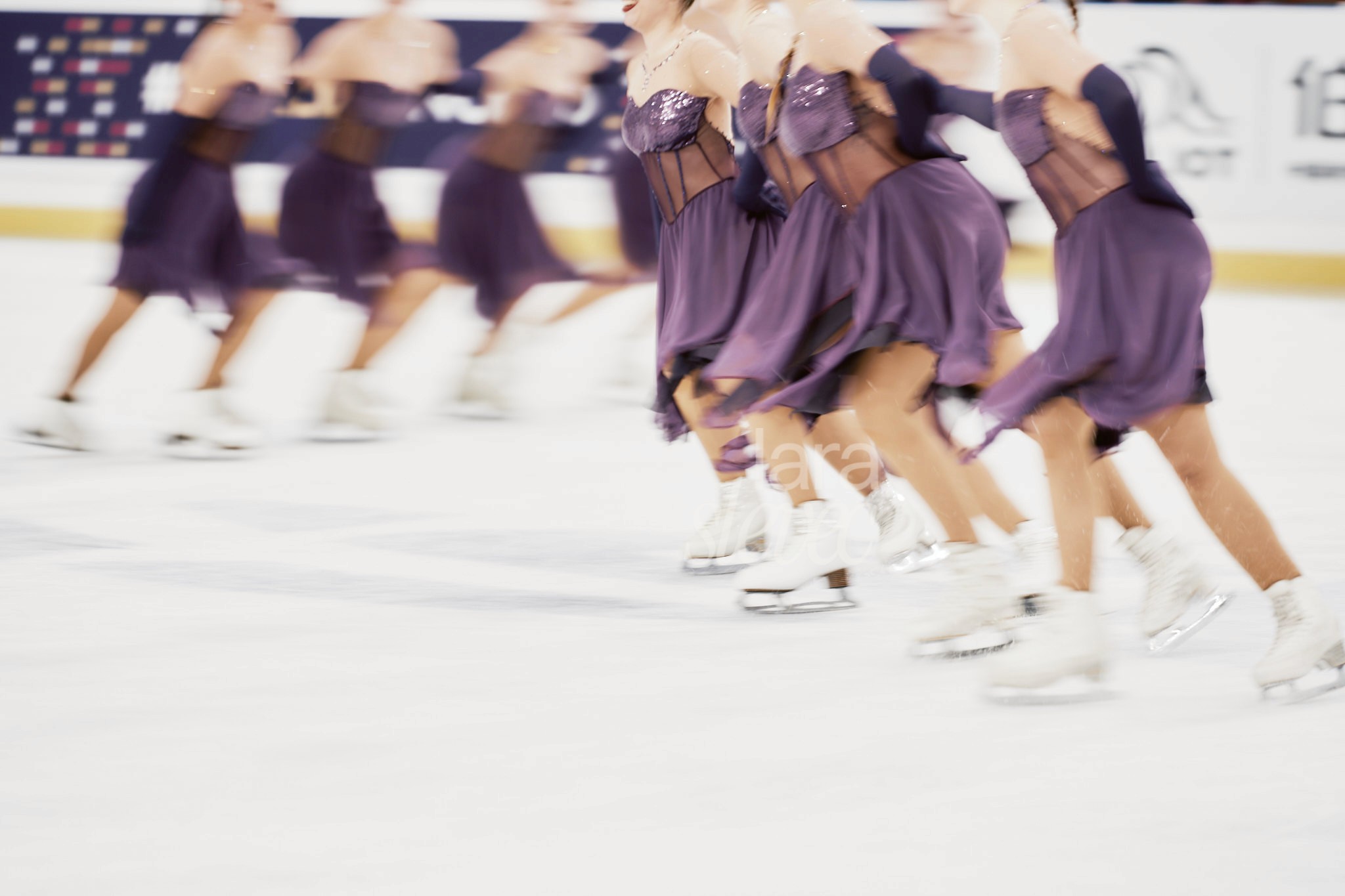Acht Synchroneiskunstläuferinnen in zwei vierer Formationen in Bewegeungsunschärfe. Team Passion. ISU Synchronized Skating Championships 2026 in Salzburg. Fotografiert von Lara Slevec.