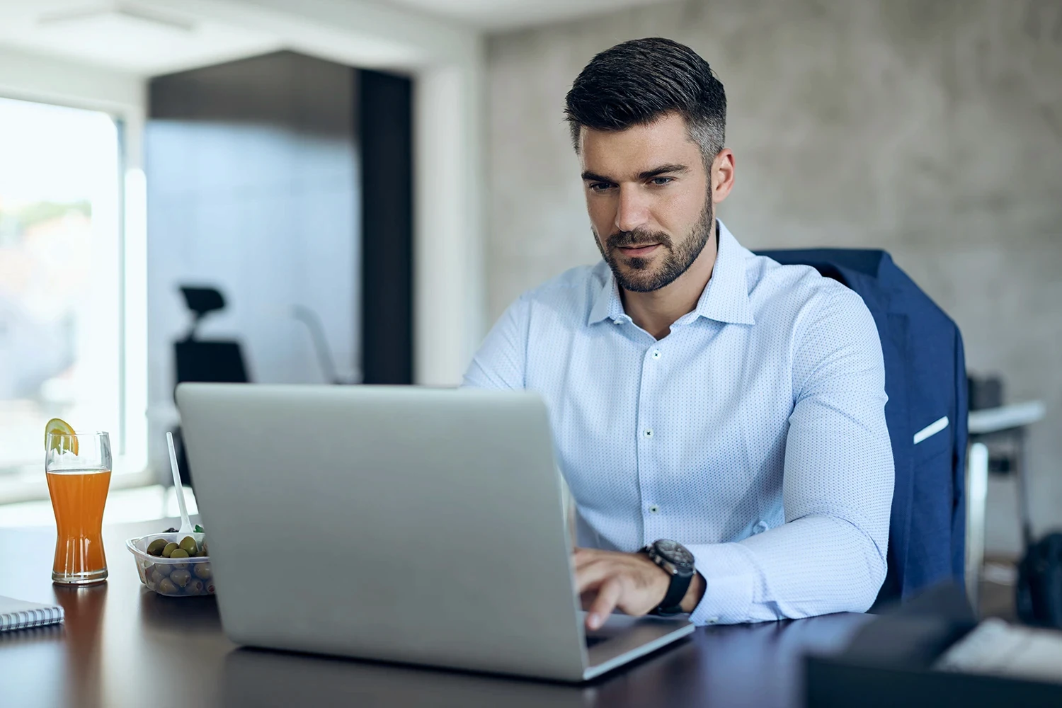 Man reading an email from a client in an office setting.