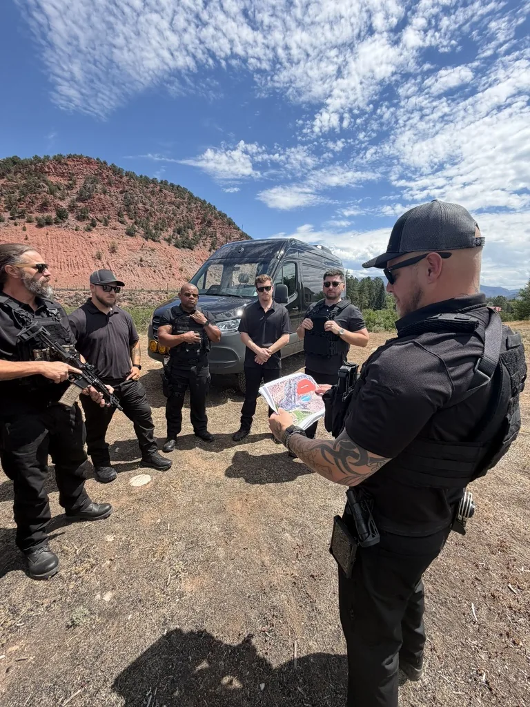 Protective team pre-operation briefing with route map beside a Sprinter