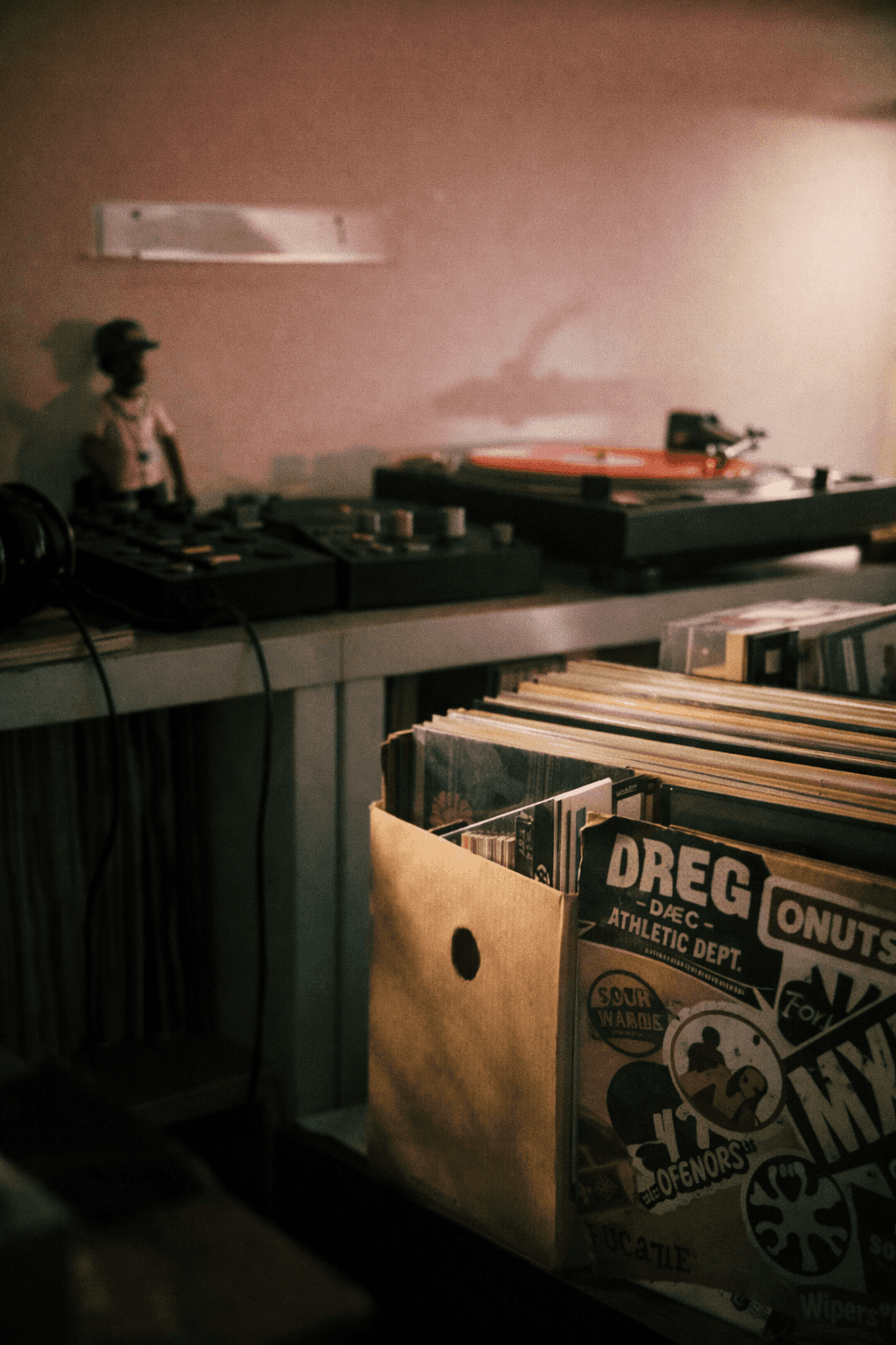 Close-up of vinyl records stored upright in a shelf with warm, nostalgic lighting.