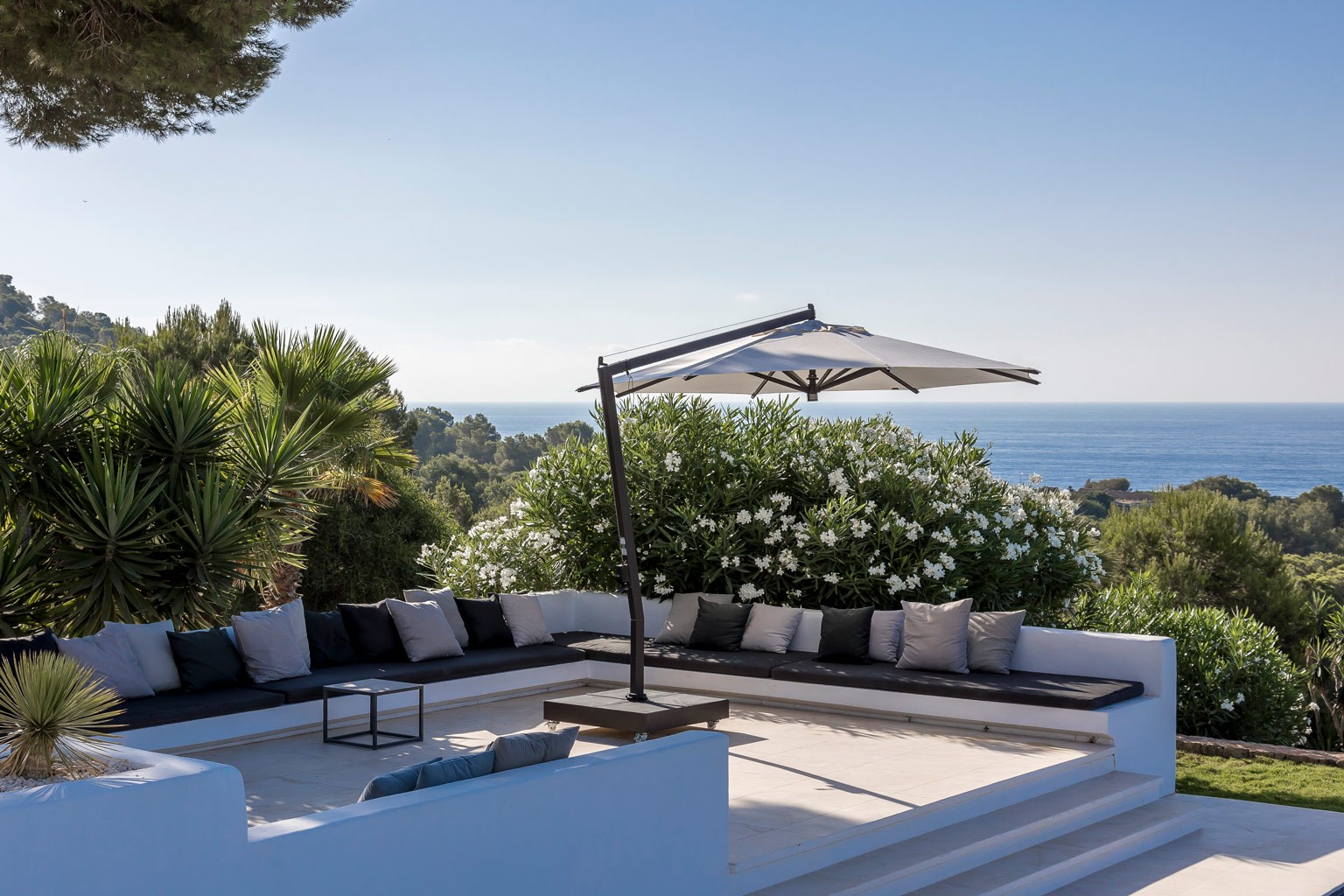 Pool lounge area at the exclusive luxury Ibiza villa, with sun loungers and shaded seating beside the pool—a private VIP estate property holiday retreat for weddings and events.