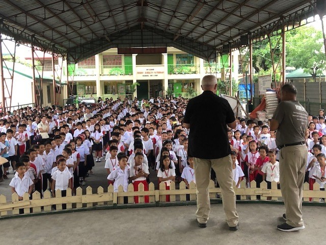 Men preaching to kids