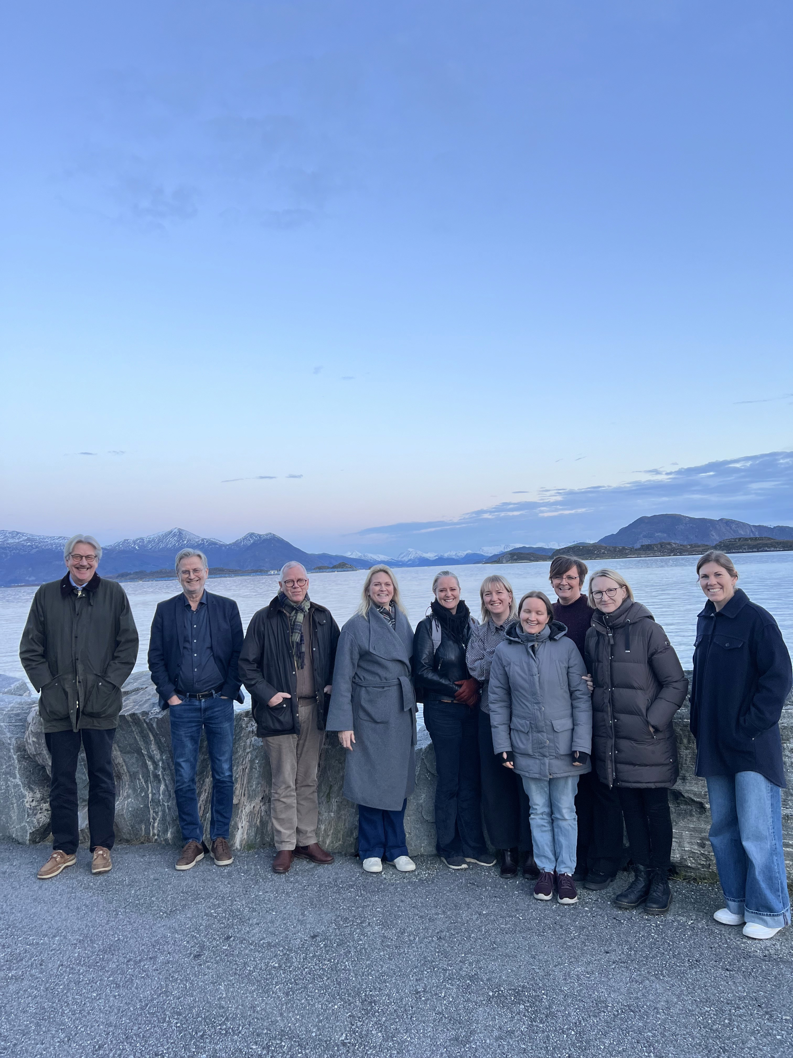A person wearing a virtual reality headset stands in front of multiple screens, engaged in a digital experience.