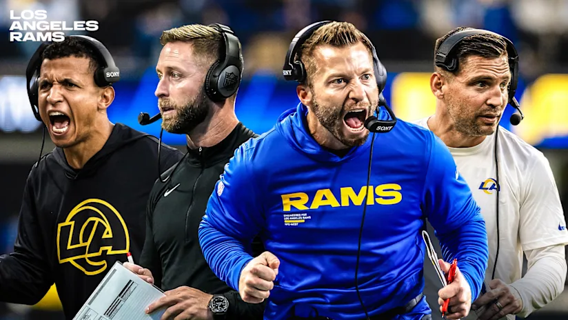 Los Angeles Rams coaching staff on the sideline wearing headsets, reacting intensely during a game with stadium lights and crowd behind them.