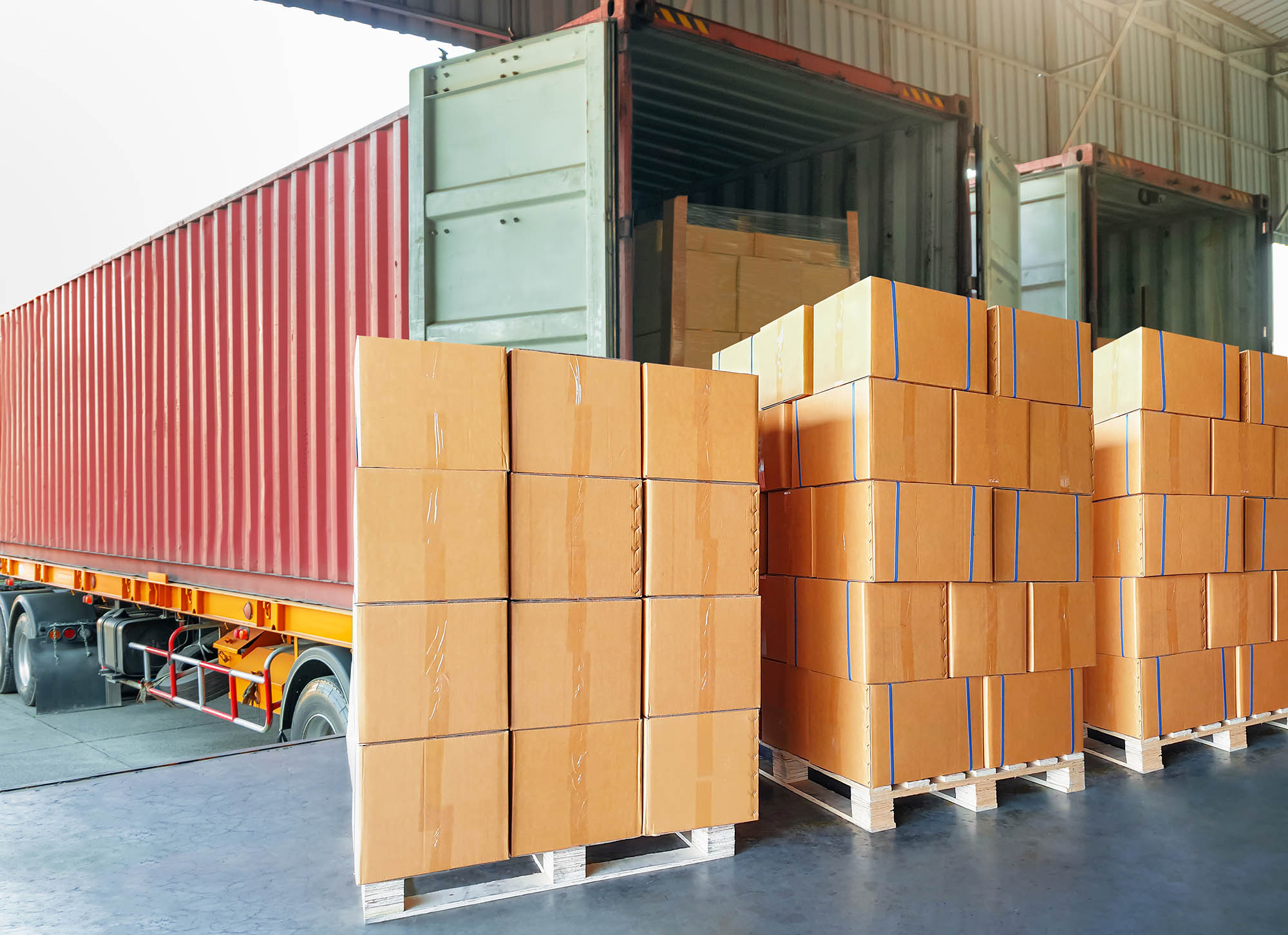 A container truck distributing goods from a warehouse – Warehouse meaning in logistics by ARENA Storage