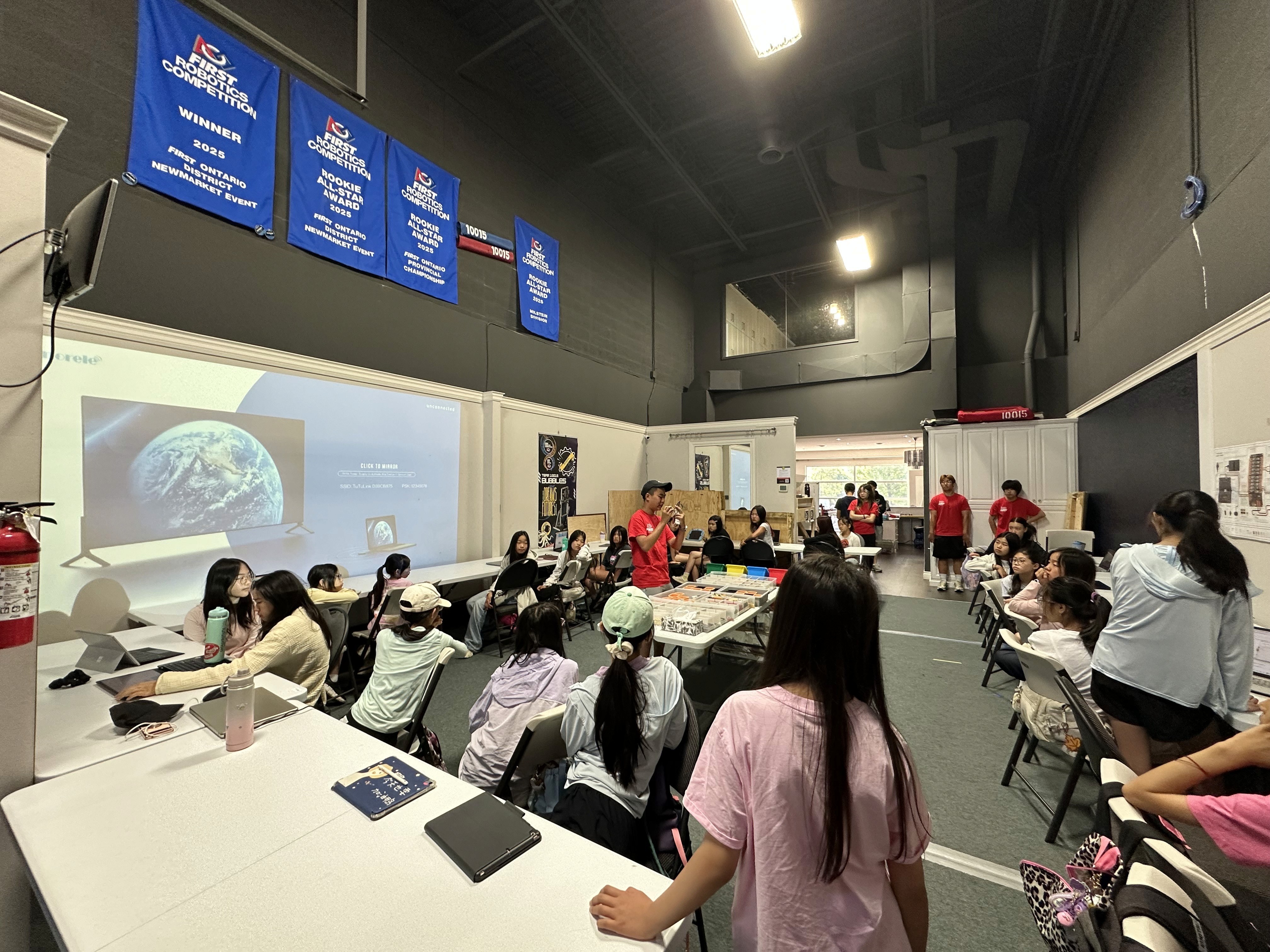 Kingsley Chen explains how to build Spike Prime robots to the girls campers at Solversmind Robotics studio.