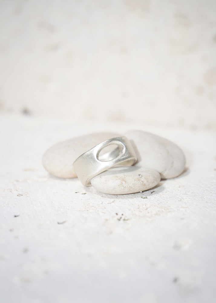 Silver ring on a white stone with a soft white background