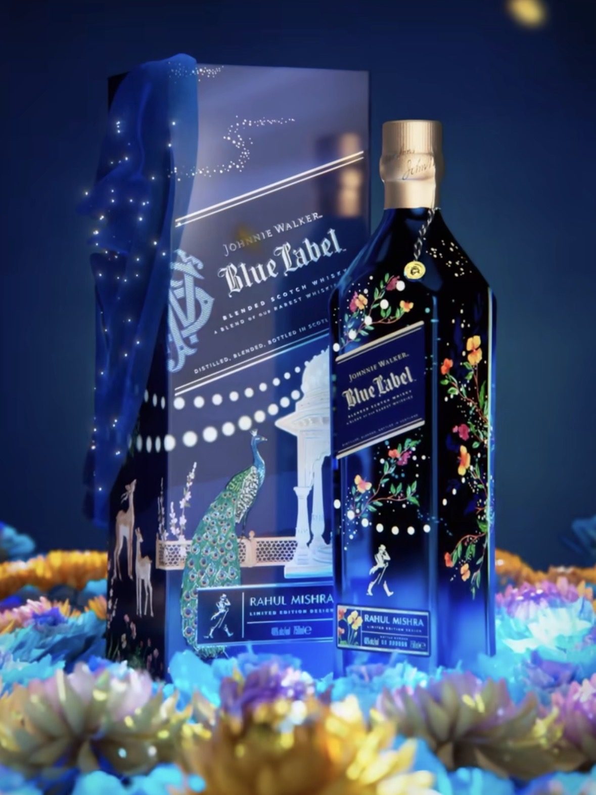 A beautifully presented Johnnie Walker Blue Label limited edition bottle designed in collaboration with Rahul Mishra, surrounded by vibrant flowers and decorative elements, reflecting the festive season.