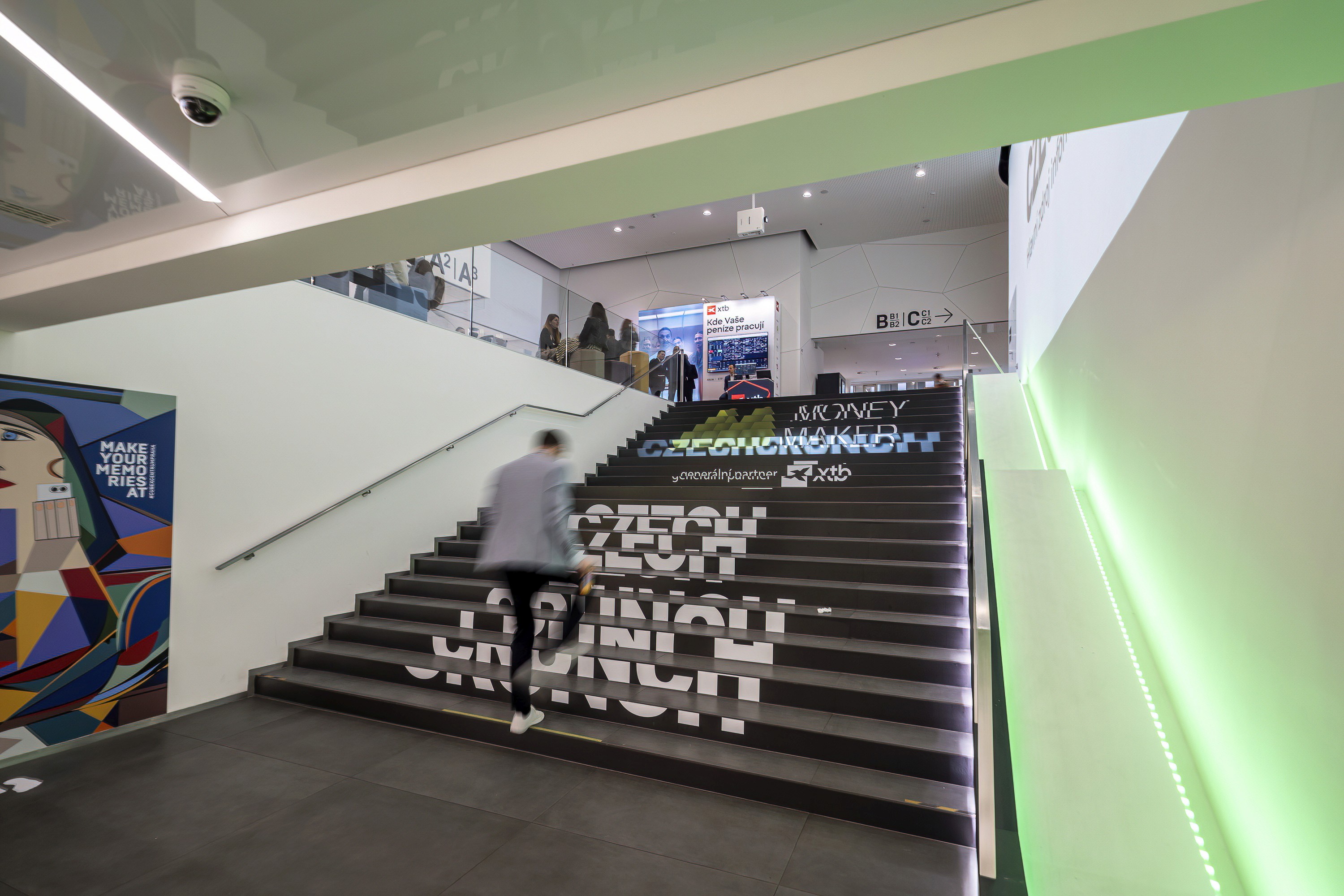Interior of a modern conference venue with branded stairs and open space.