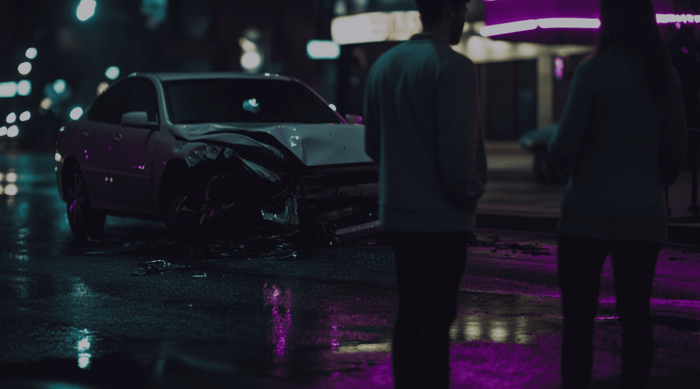 Duas pessoas em frente a um carro batido.