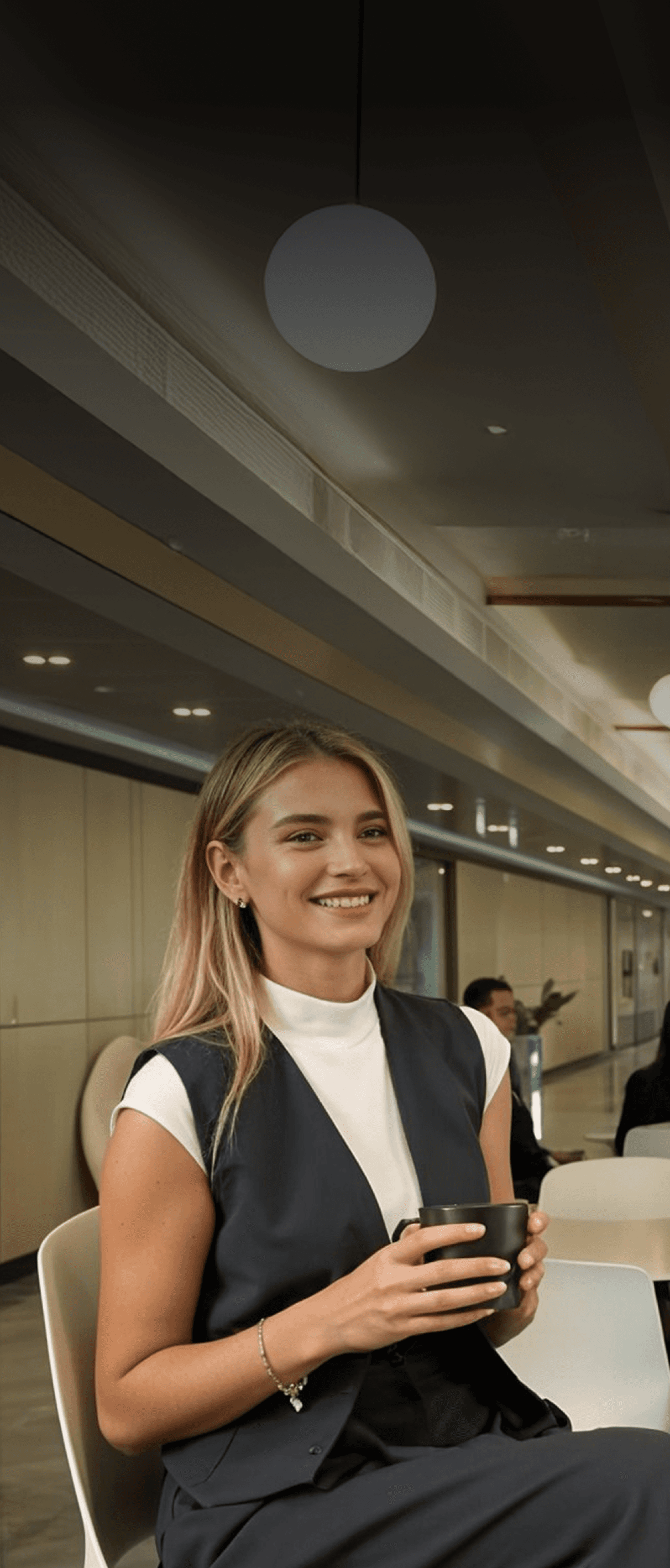 Dubai South Business Hub Free Zone -Smiling woman with blonde hair, wearing a white shirt and navy vest