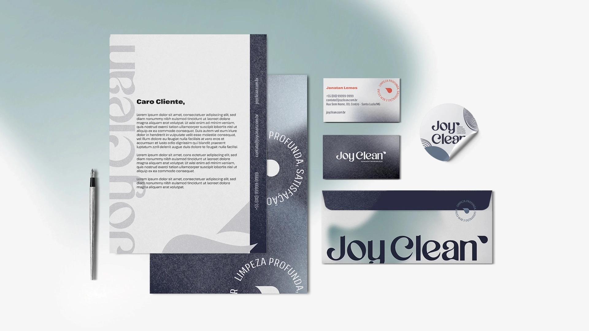 Conjunto de itens de papelaria institucional da Joy Clean arranjados sobre mesa, incluindo papel timbrado, cartões de visita, envelope corporativo e adesivo circular.