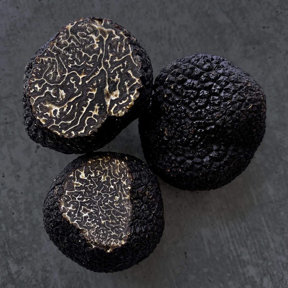Black truffles cut open to show their marbled interiors
