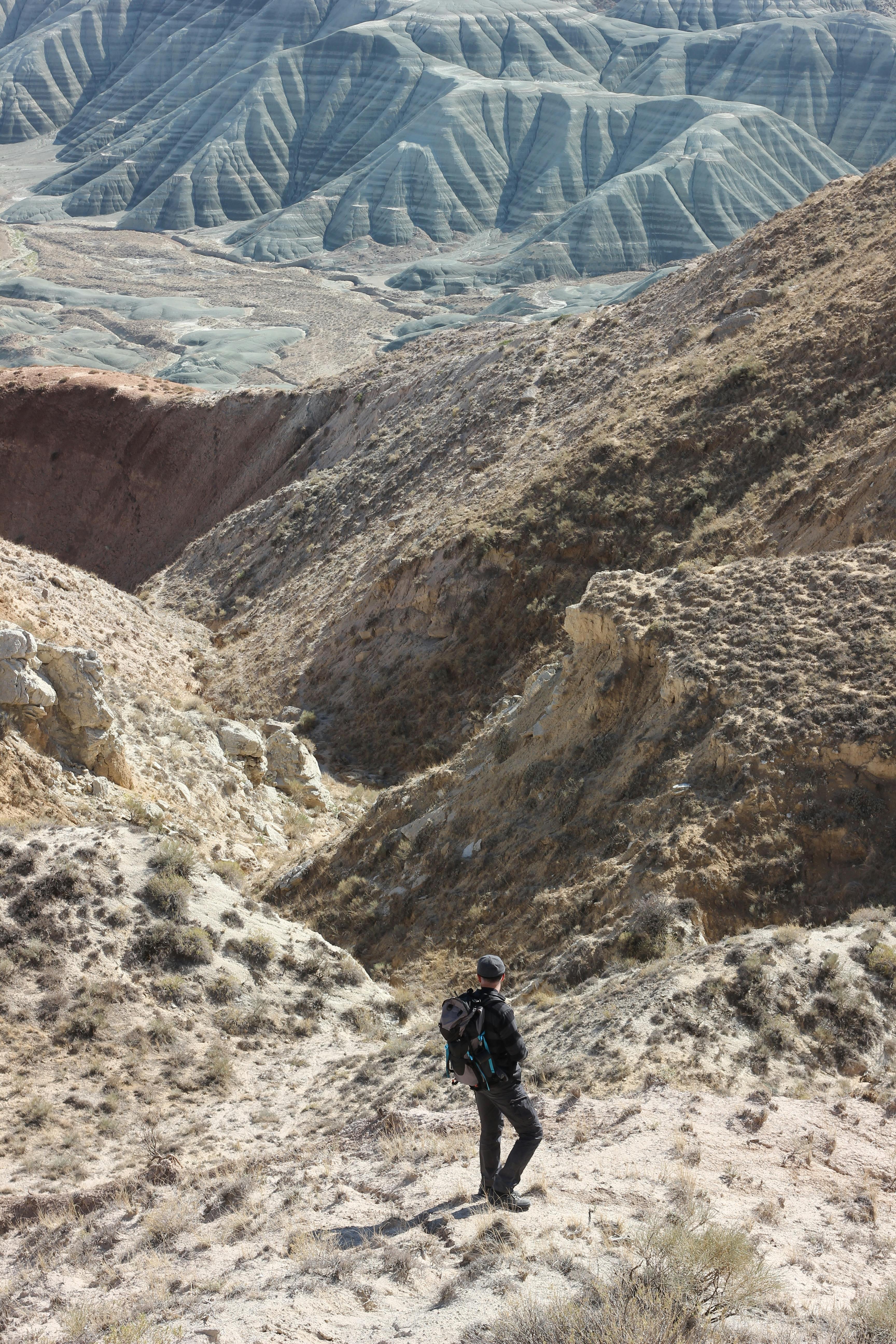 trekking in mountains with a male in the middle of the pathway