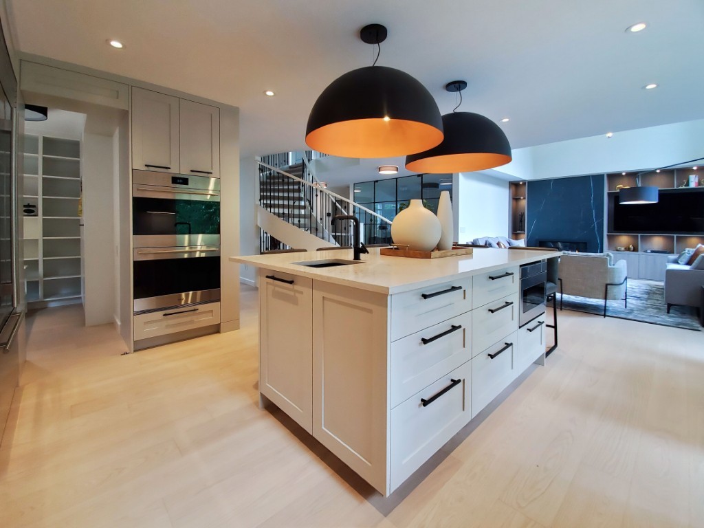Image of Modern kitchen interior with island, pendant lights, and stainless steel appliances by KHD Homes design-build team.