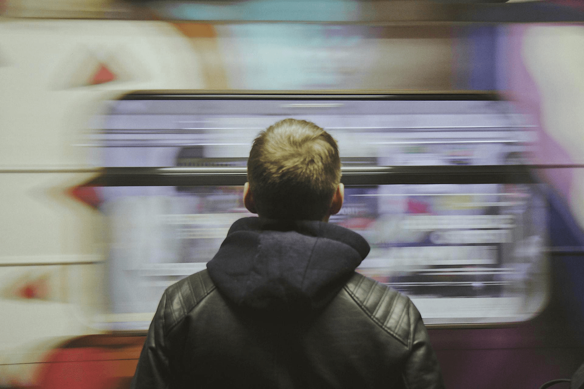 A man standing infront of a subway train, motion blur