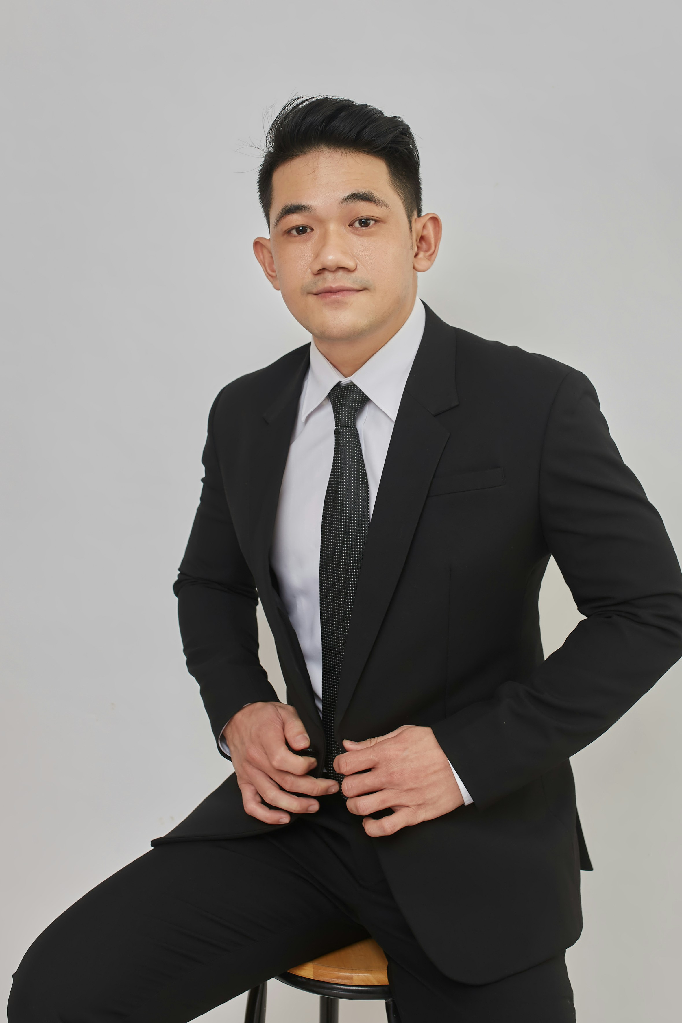 A man in a suit sitting on a stool