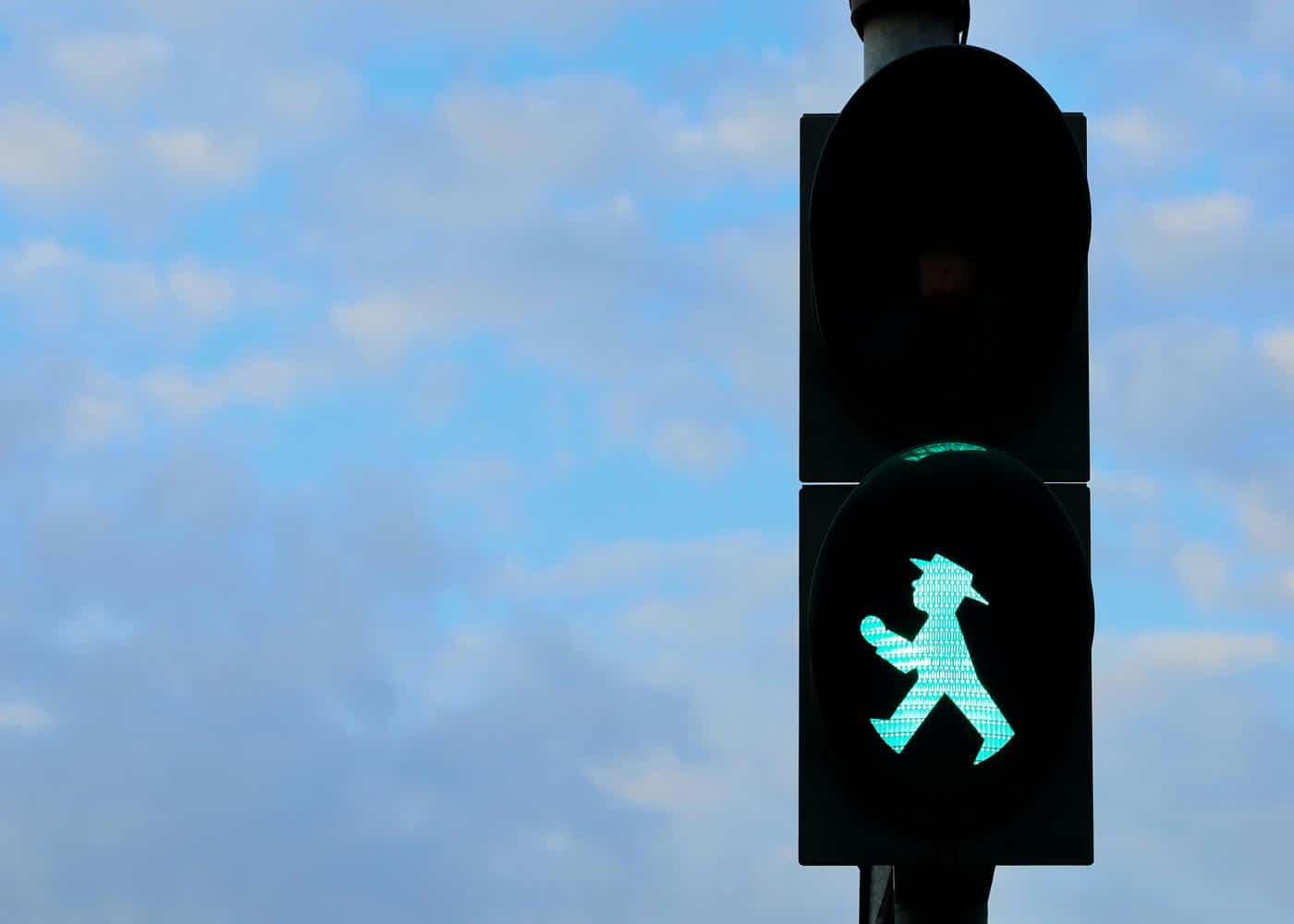 Crossing traffic light showing green light with figure of man walking