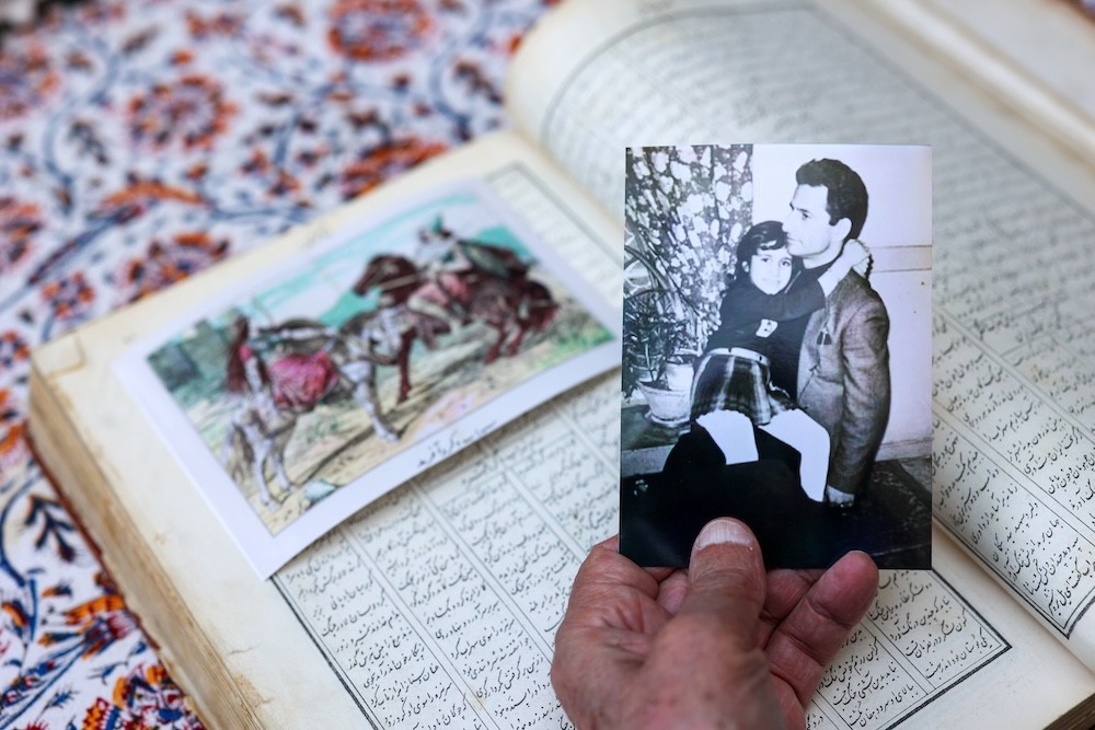 Bubjan with book and speaking to camera