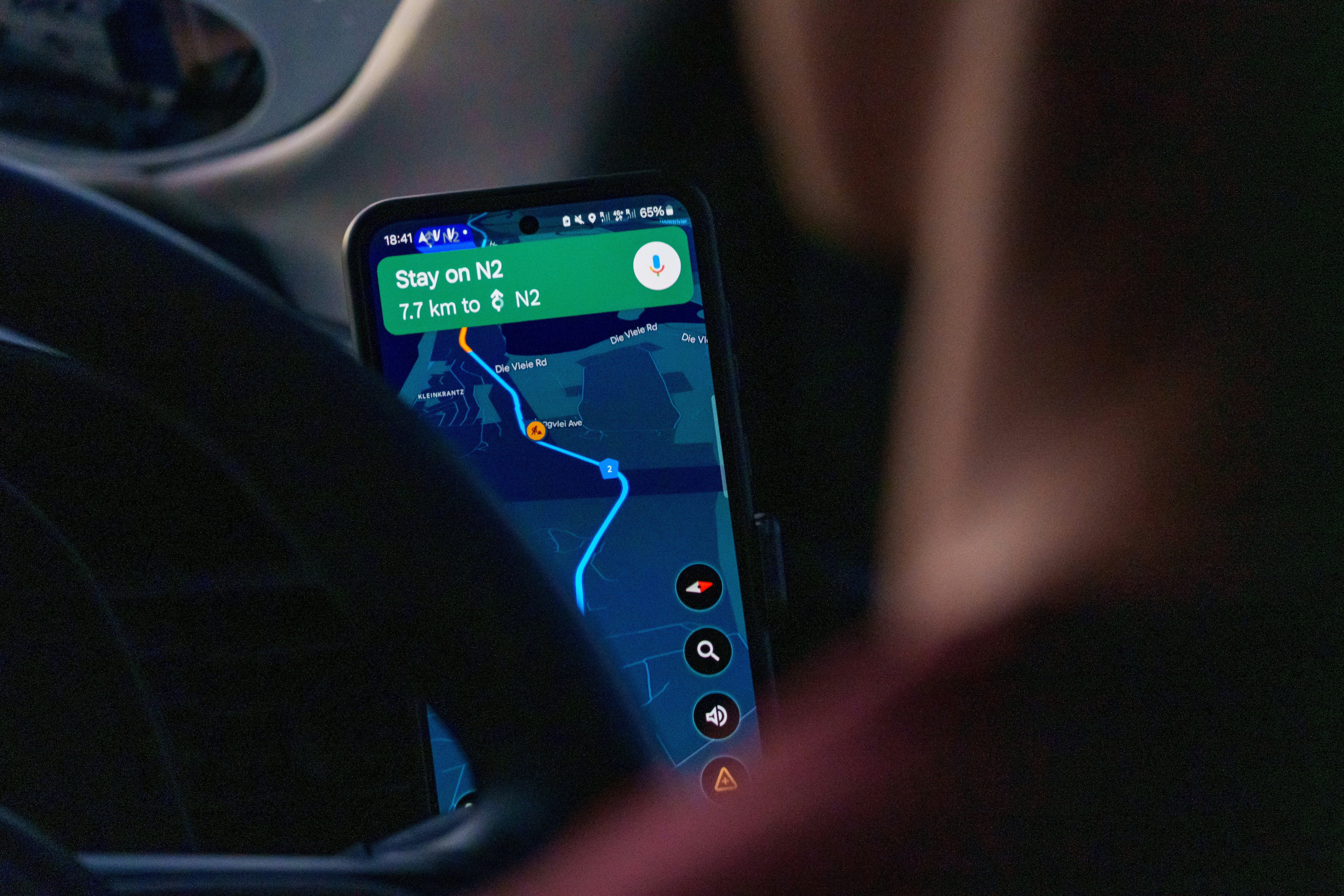 Person using navigation app on smartphone inside car.