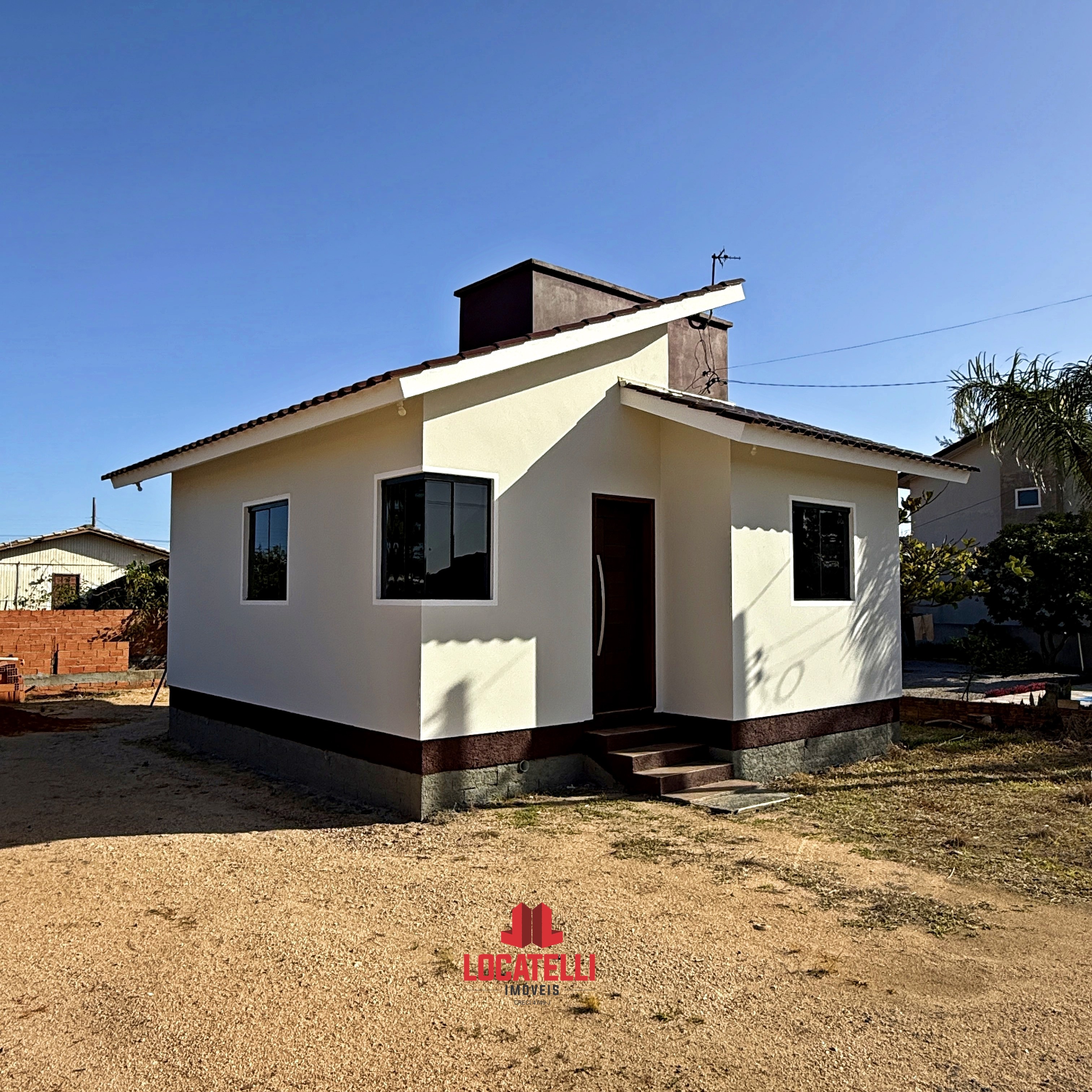 A modern brick house with a two-car garage, well-manicured lawn, and clear blue sky in the background.