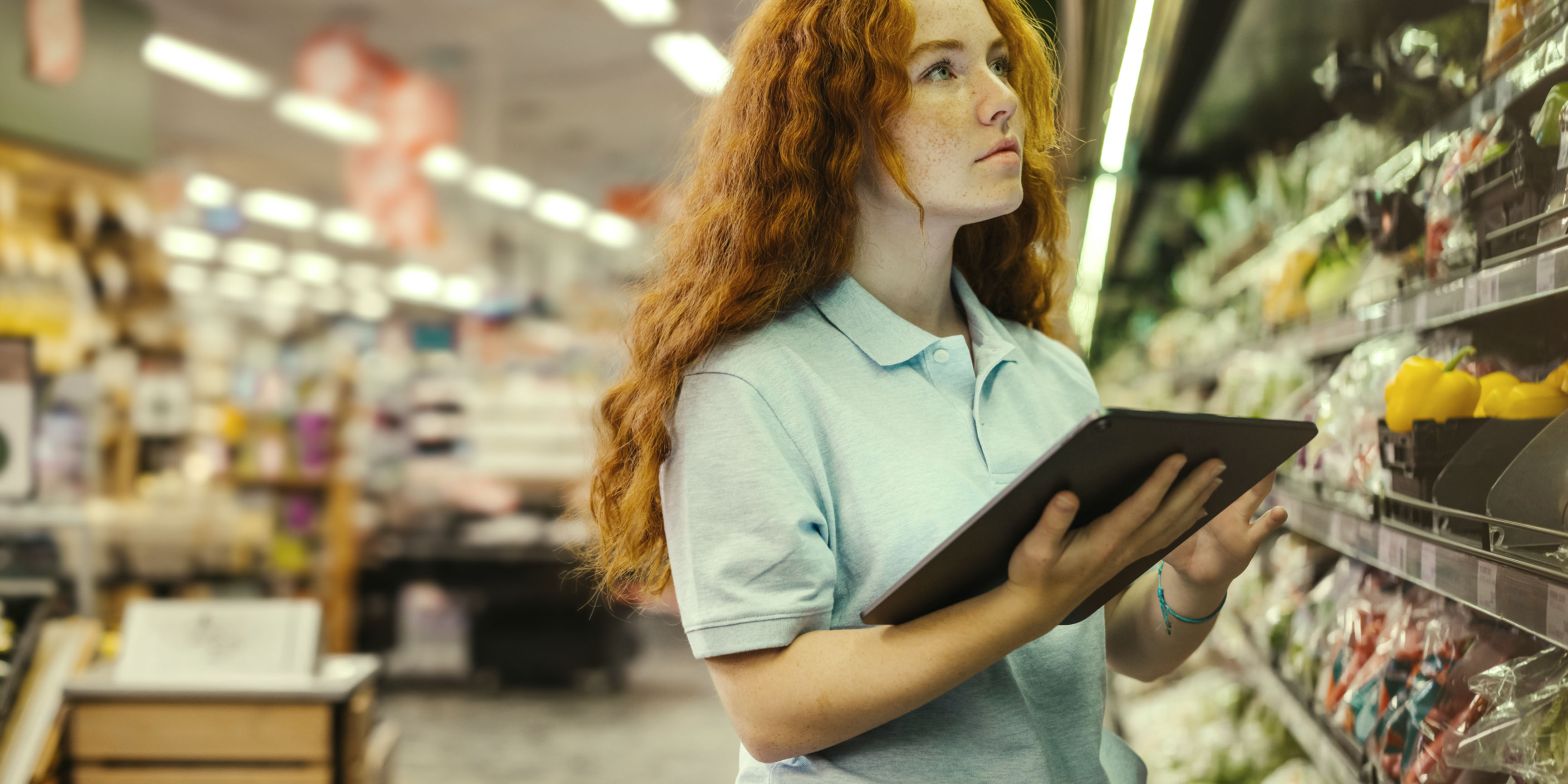 Retail worker using a tablet to manage inventory, highlighting how Fulfilled by TikTok helps sellers track stock and warehouse operations.