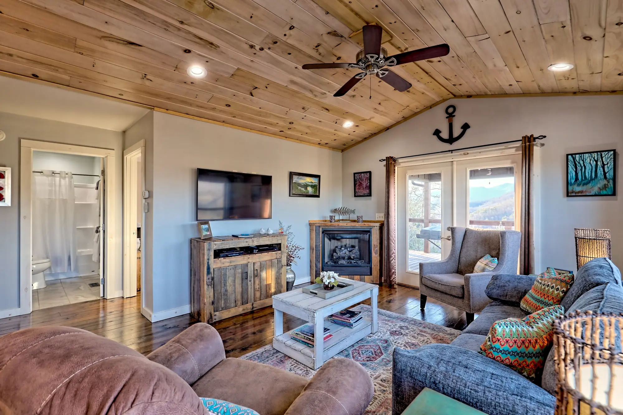 Eagles Landing living room with a gas fireplace, TV and French doors to the deck