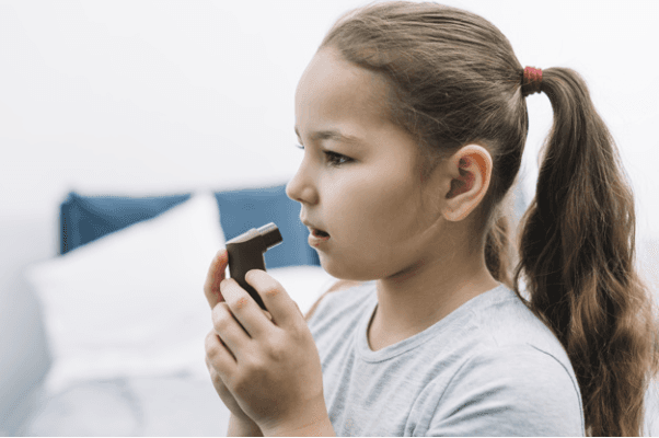 asthama girl using inhaller