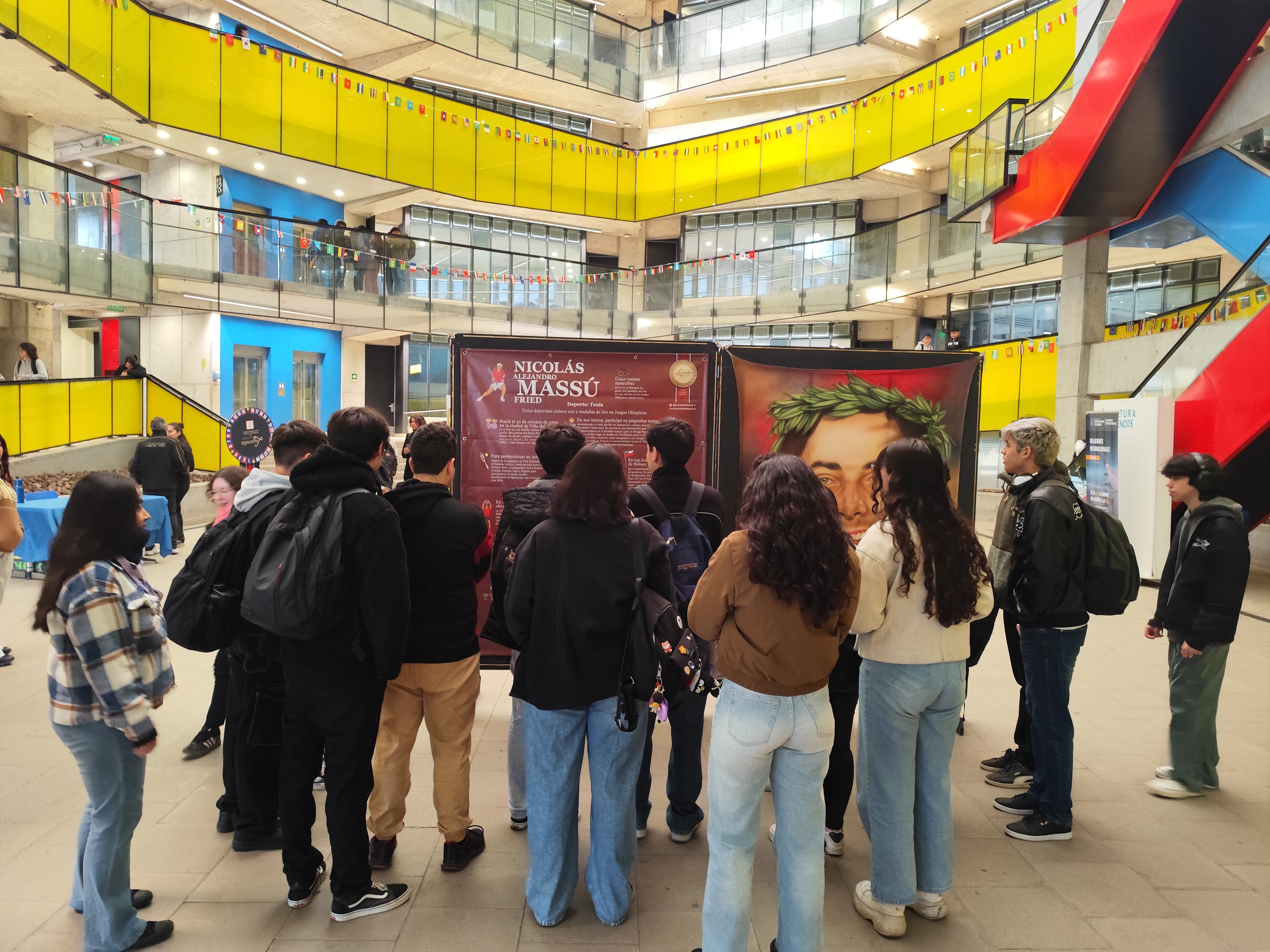 Espectadores admirando la pintura de Nicolás Massú, tenista olímpico chileno, en la exposición Leyendas del Deporte en USACH.