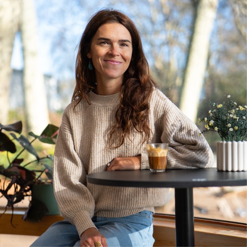 portait of a woman sitting at a table and smiling