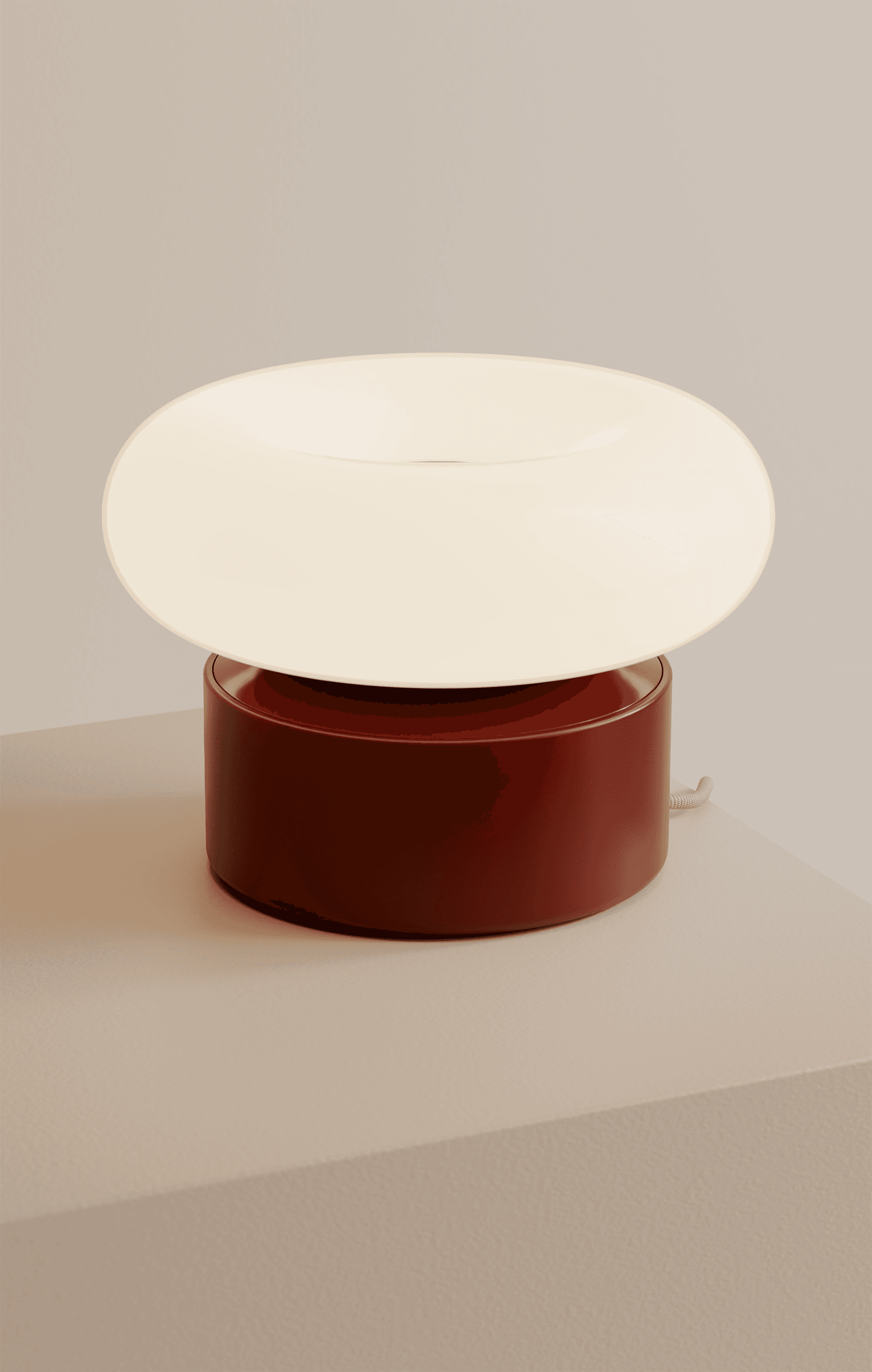 A burgundy nomadic lamp with a donut shaped lamp shade.
