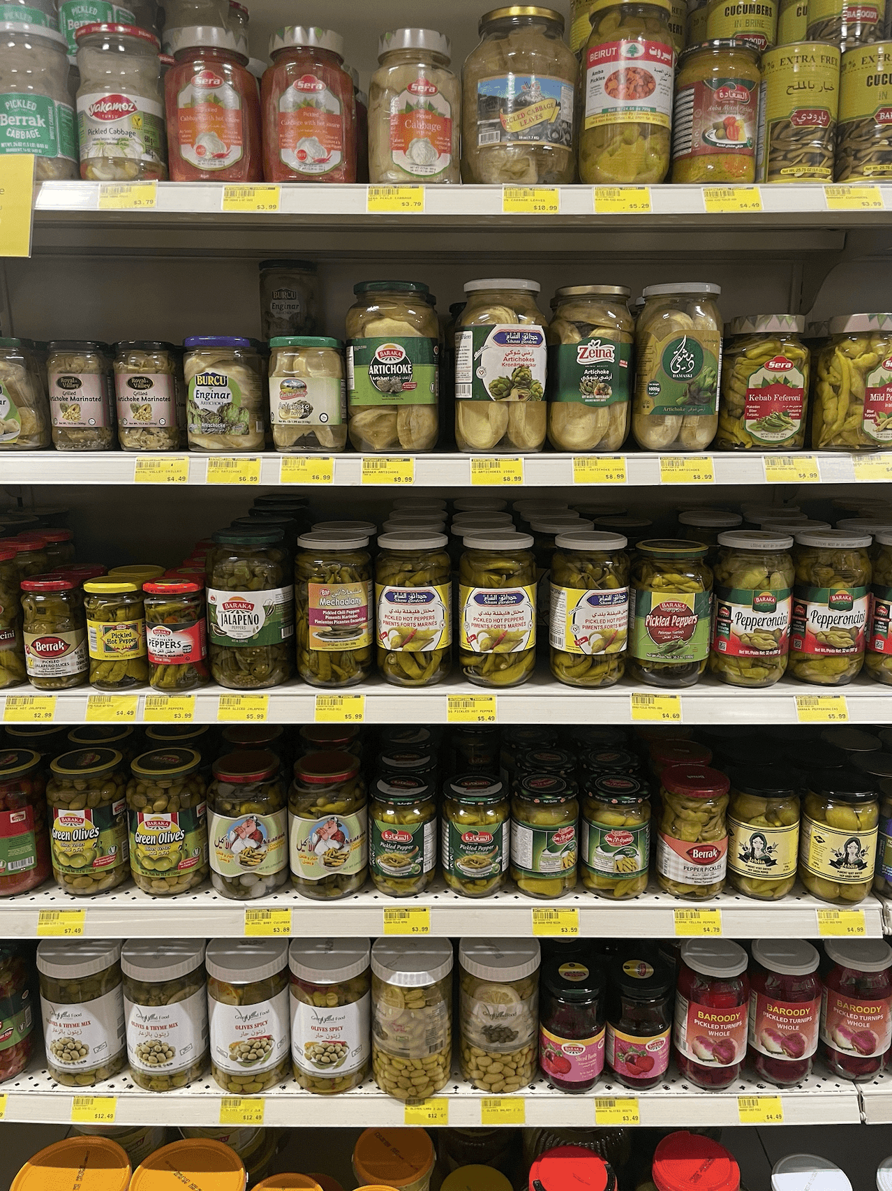 Assorted pickled vegetables and peppers in jars at International Food Market Orlando.